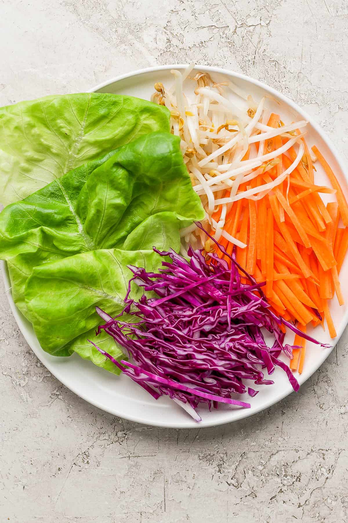 Fresh spring roll bowl ingredients on a white plate.