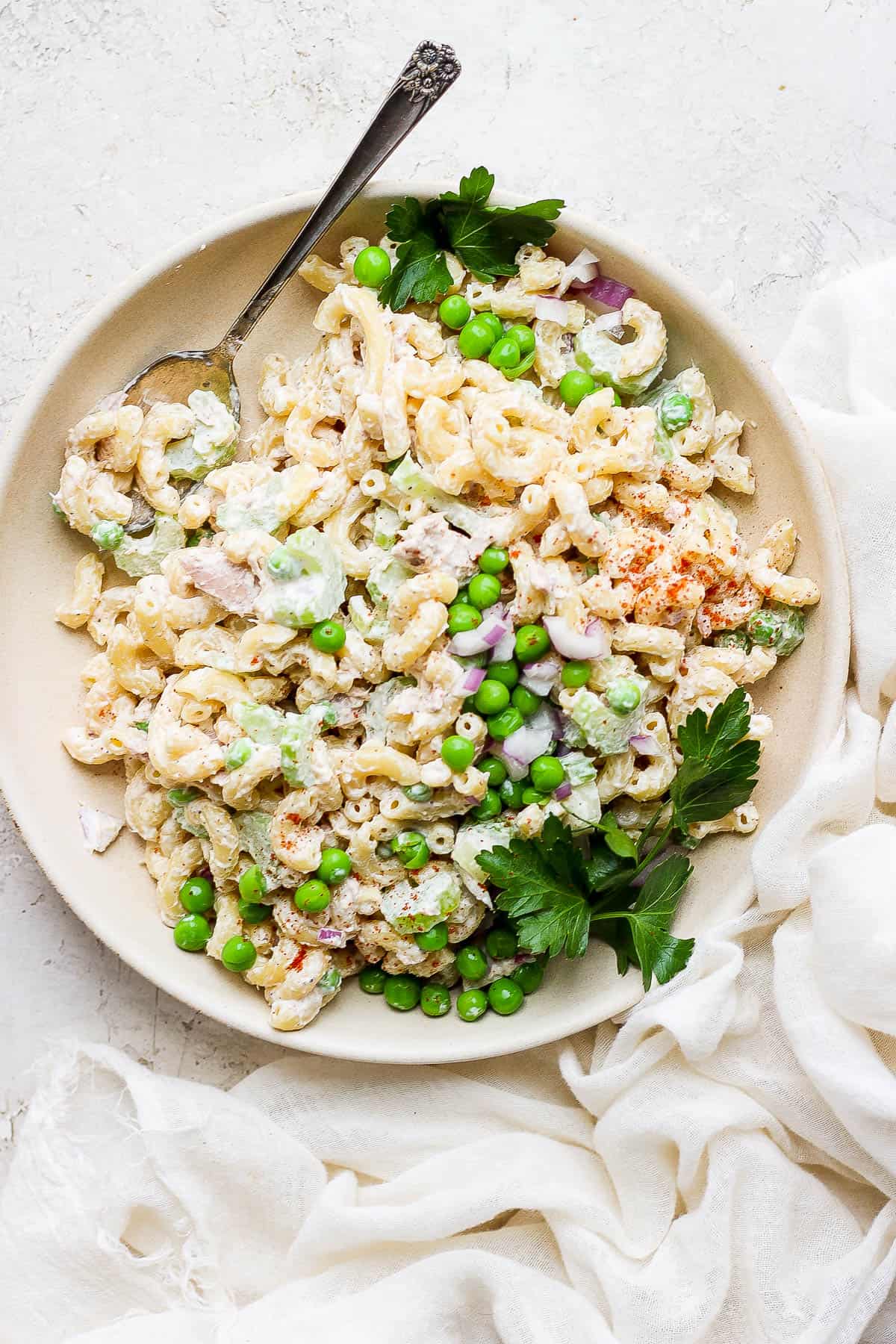 Tuna macaroni salad on a plate with fresh parsley.
