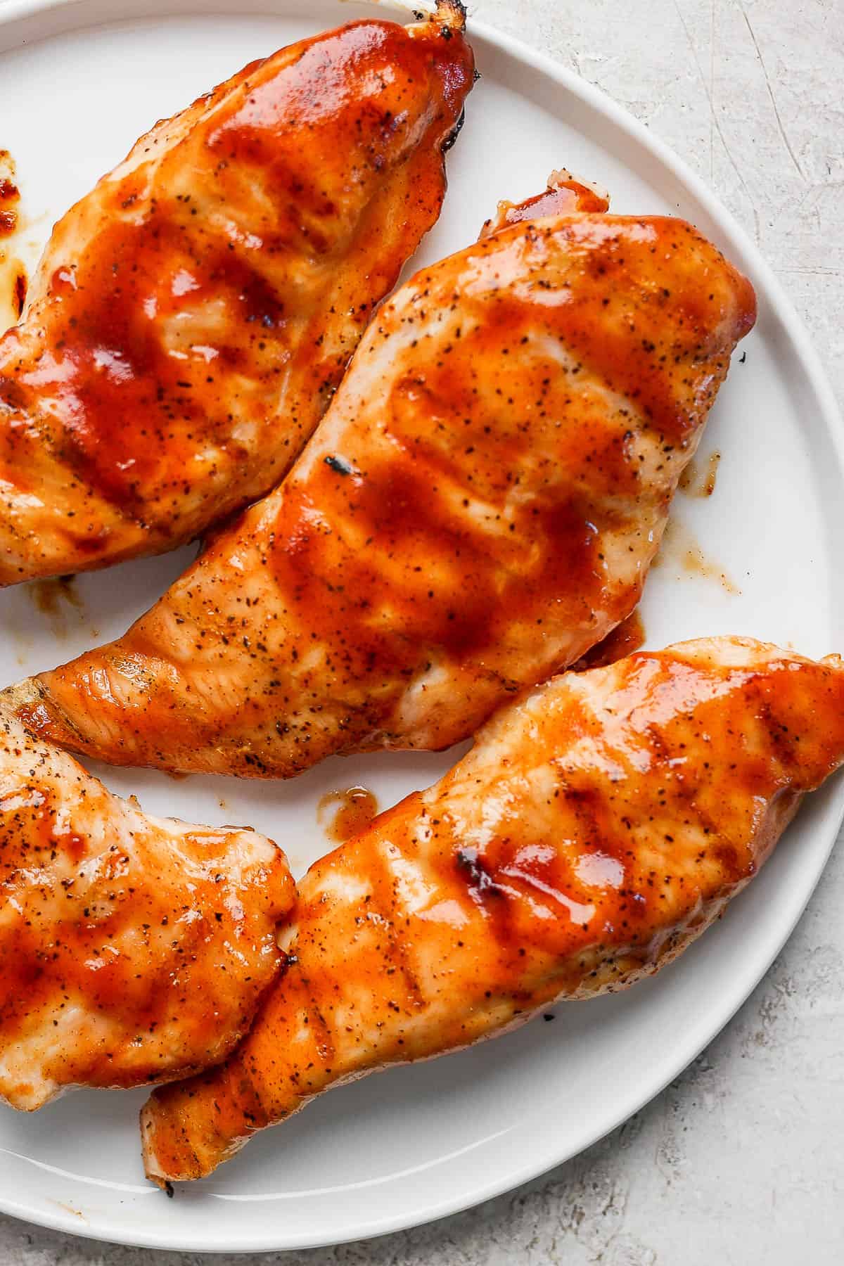 Grilled bbq chicken breasts on a plate.