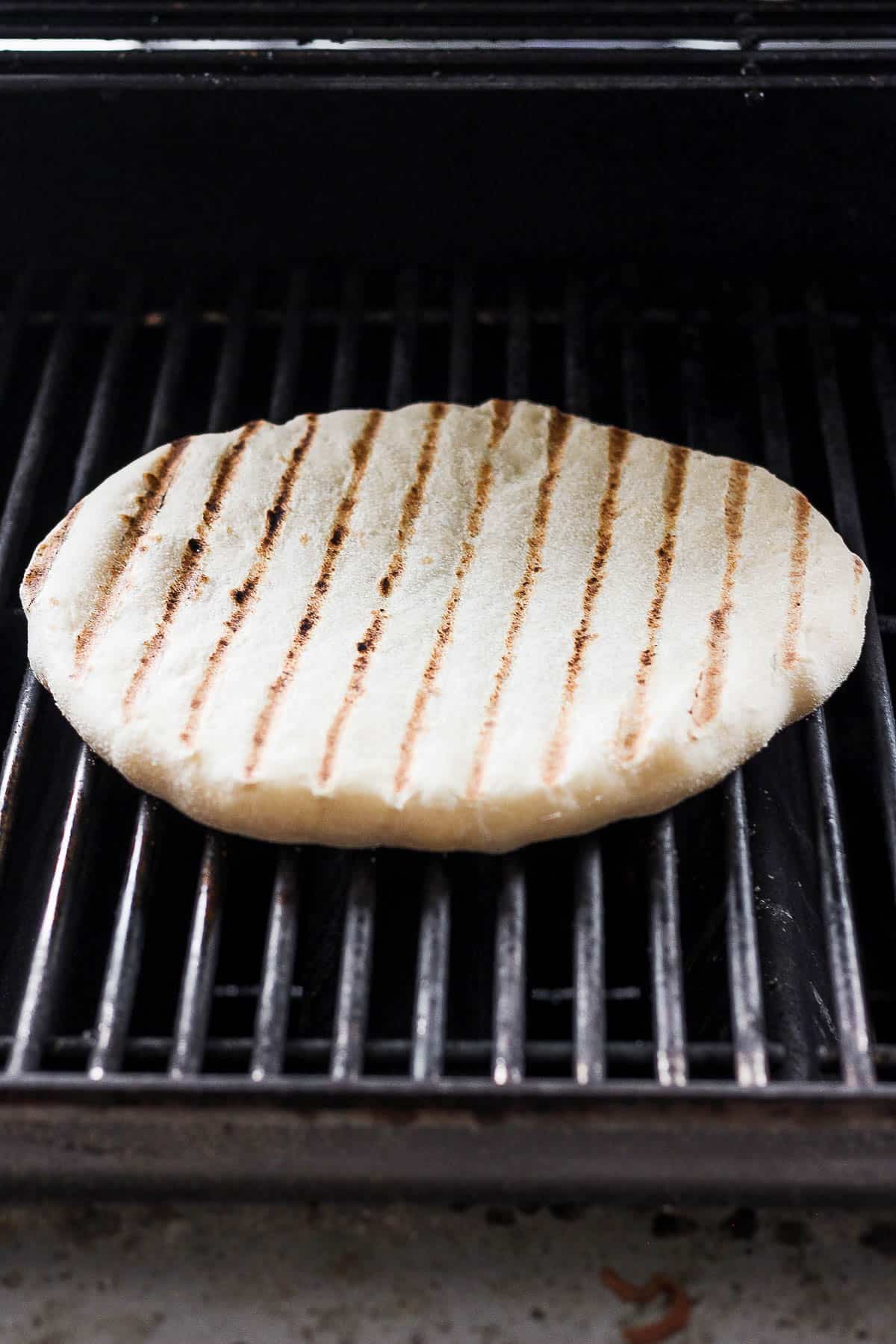 Pizza crust after being flipped on the grill.