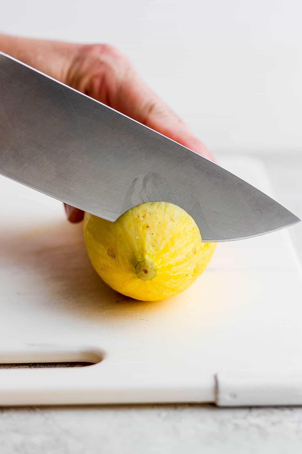 The bottom being cut off the yellow squash.