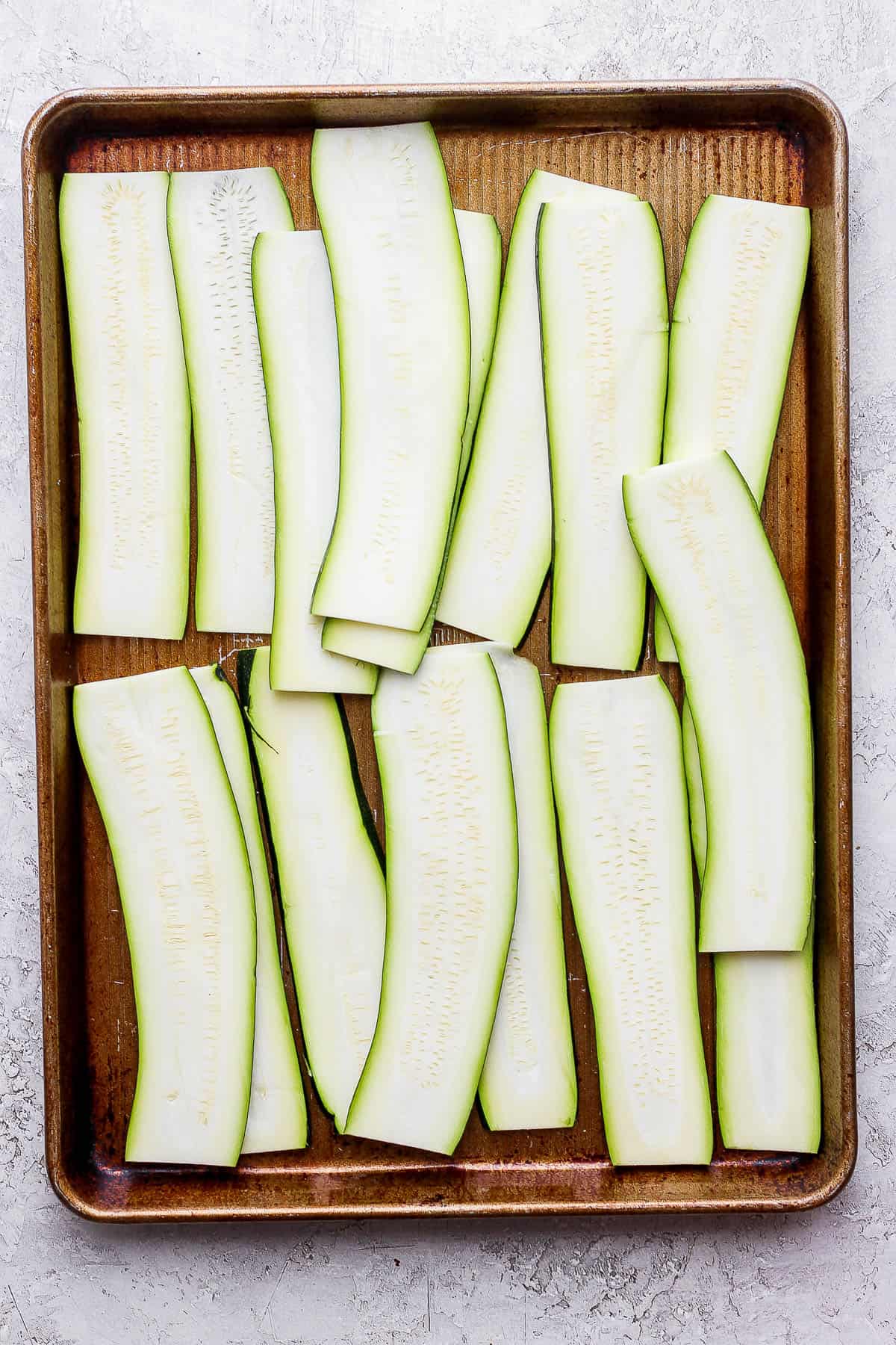 Zucchini planks on a baking sheet.
