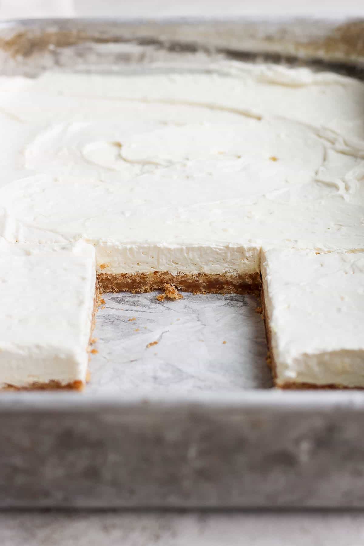 A piece of the key lime cheese cake missing from the baking sheet.