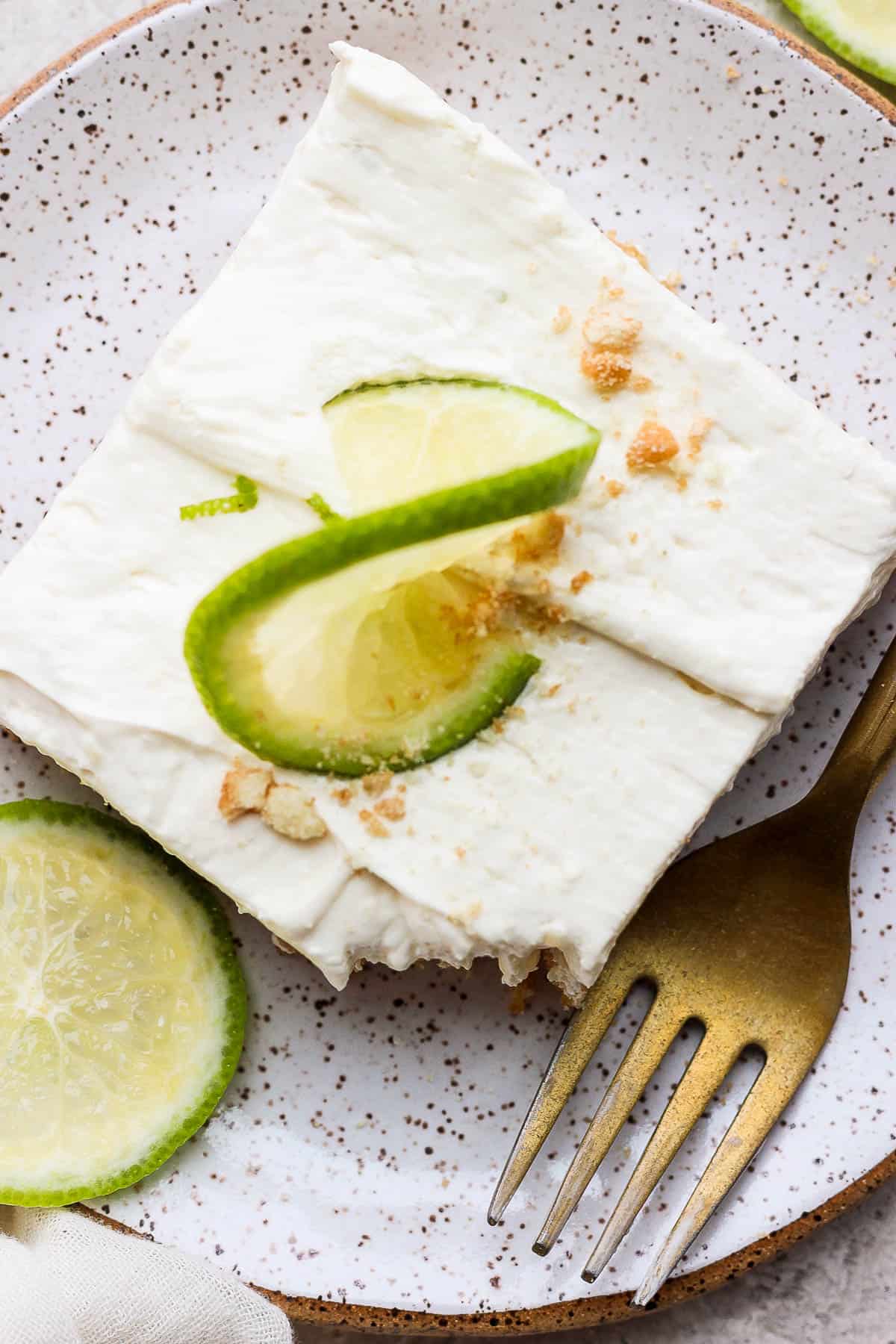 Key lime cheese cake on a plate topped with a slice of lime.