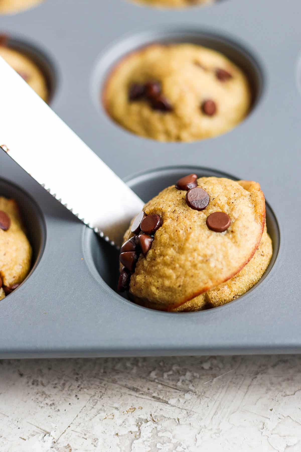 A butter knife popping the pancake bite out of the muffin tin.