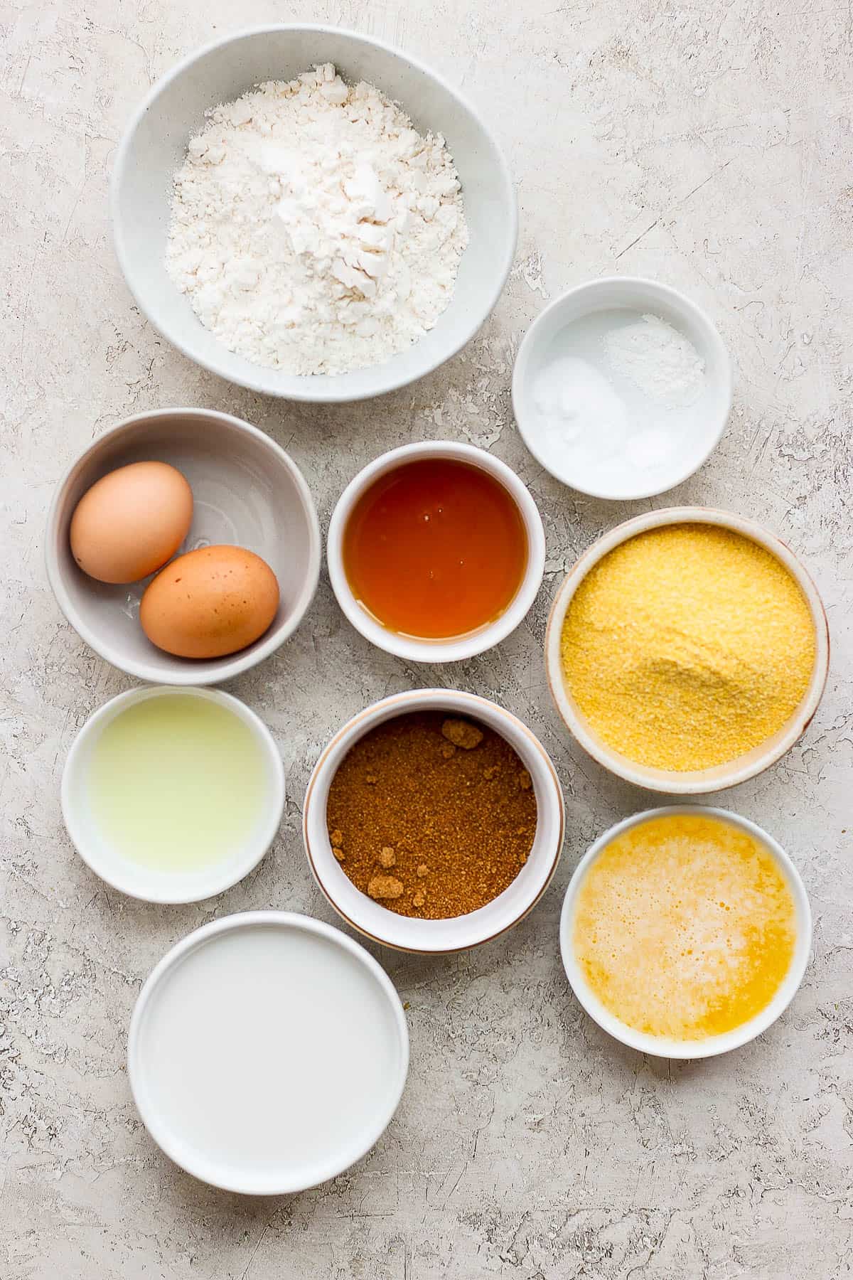 The ingredients for cornbread muffins in separate bowls.