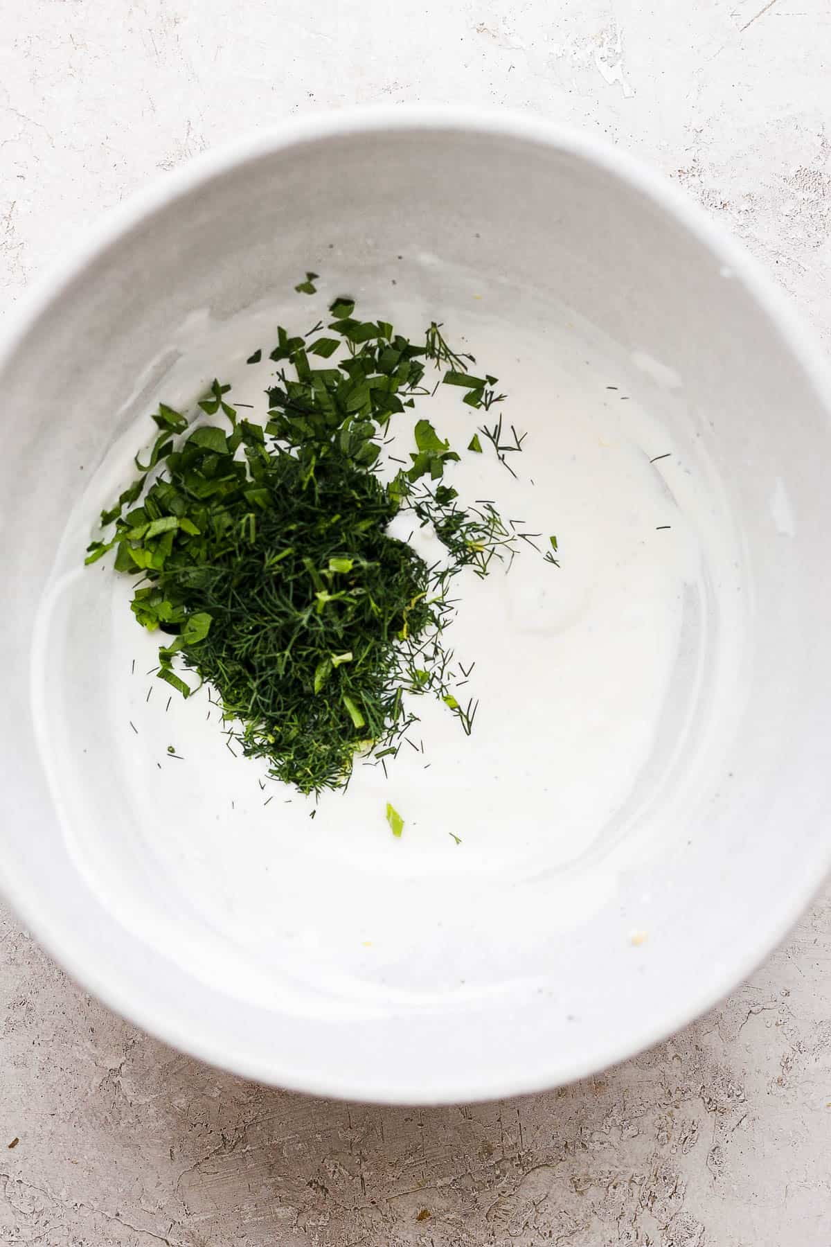 Sour cream, mayo, white vinegar, dill, parsley, lemon juice, lemon zest, garlic, pepper and pinch of salt in a large bowl. 