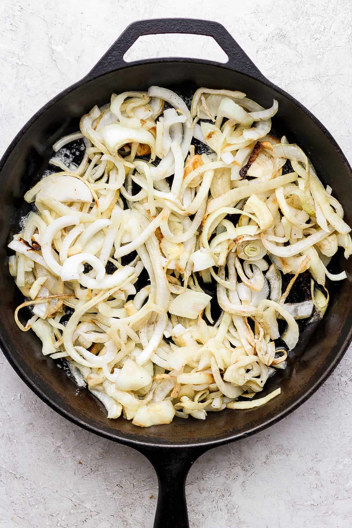 Smoked onions in a cast iron skillet with melted butter.
