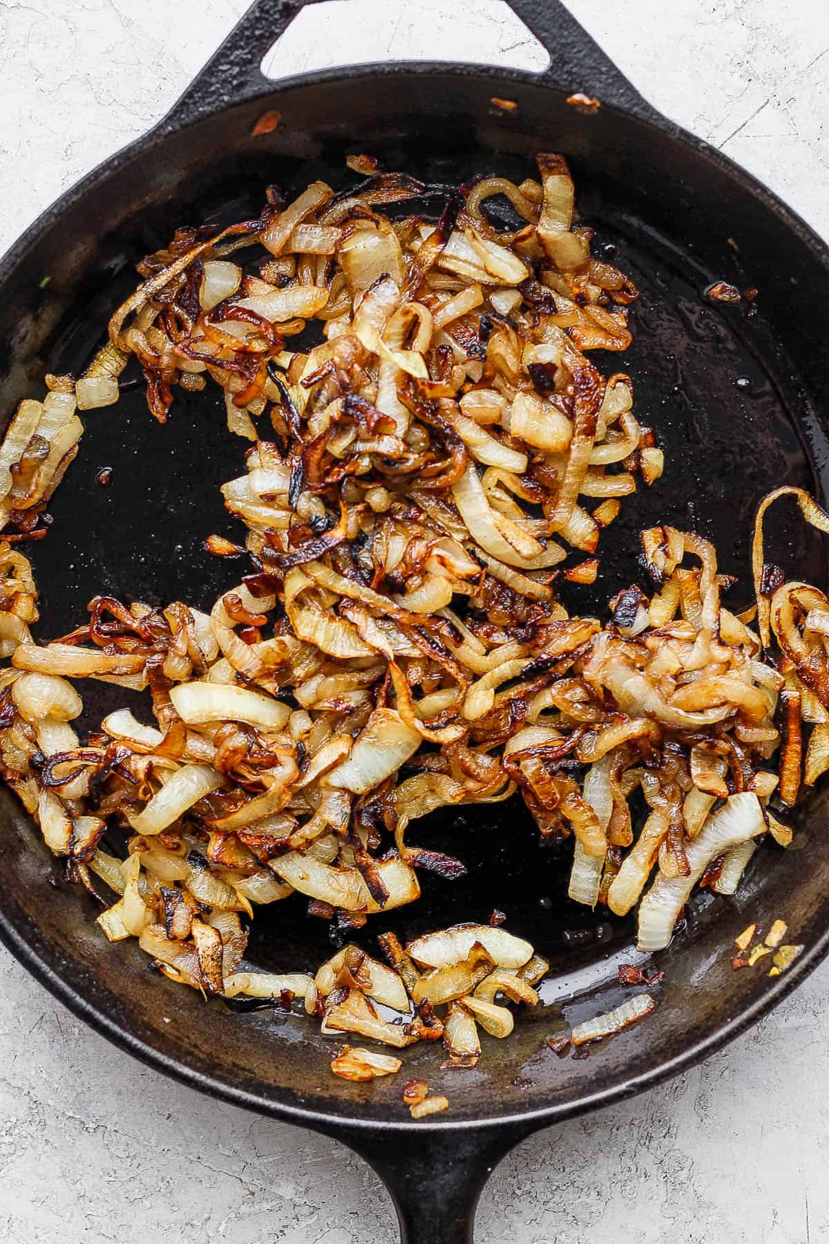 Caramelized onions in a cast iron skillet with garlic.