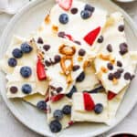 Top down shot of a plate of frozen yogurt bark pieces.