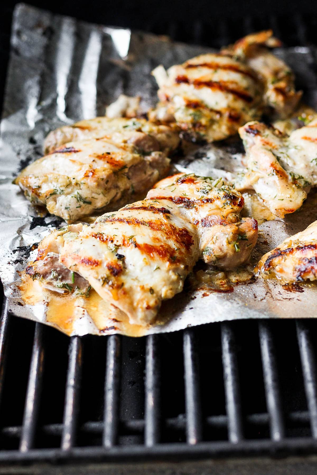 A sheet of heavy duty foil on top of grill grates.  The marinated chicken is on top of the foil.