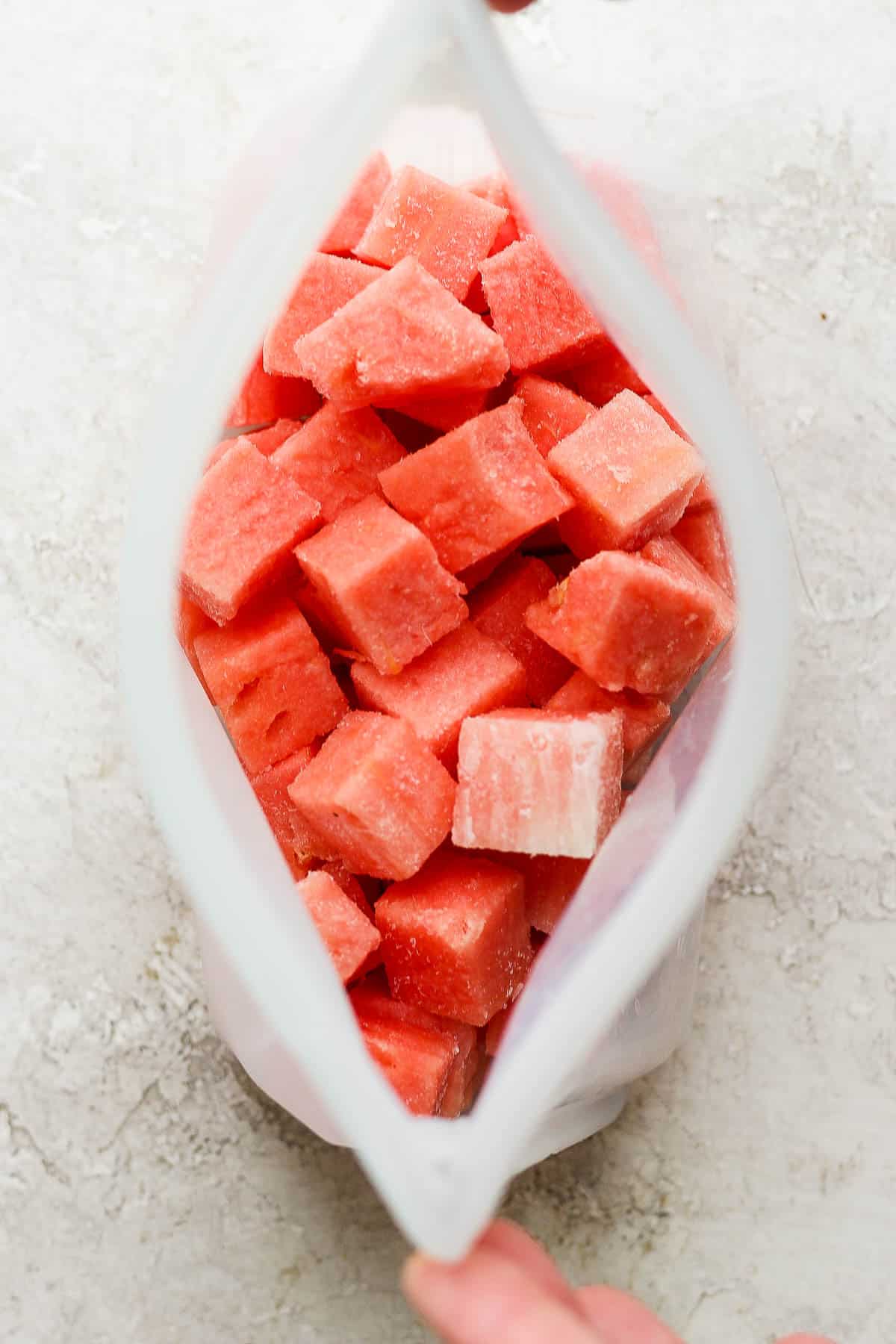 Frozen watermelon cubes in a stasher bag.
