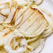 A plate of smoked onions with char marks.