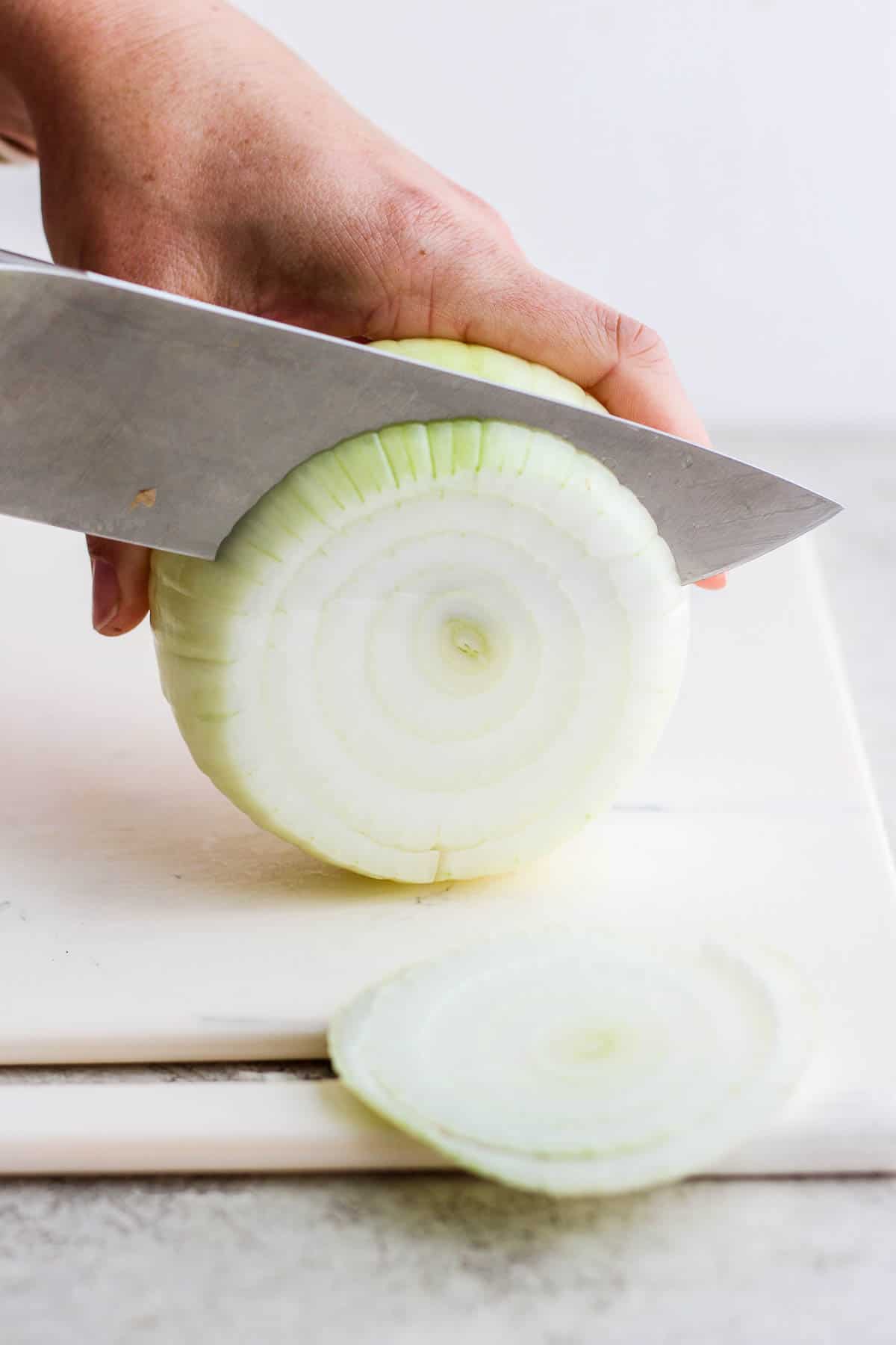 A large onion being cut into slices.