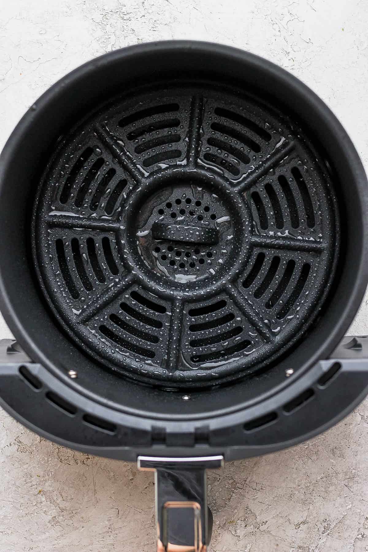 The air fryer basket after it was sprayed with cooking spray.