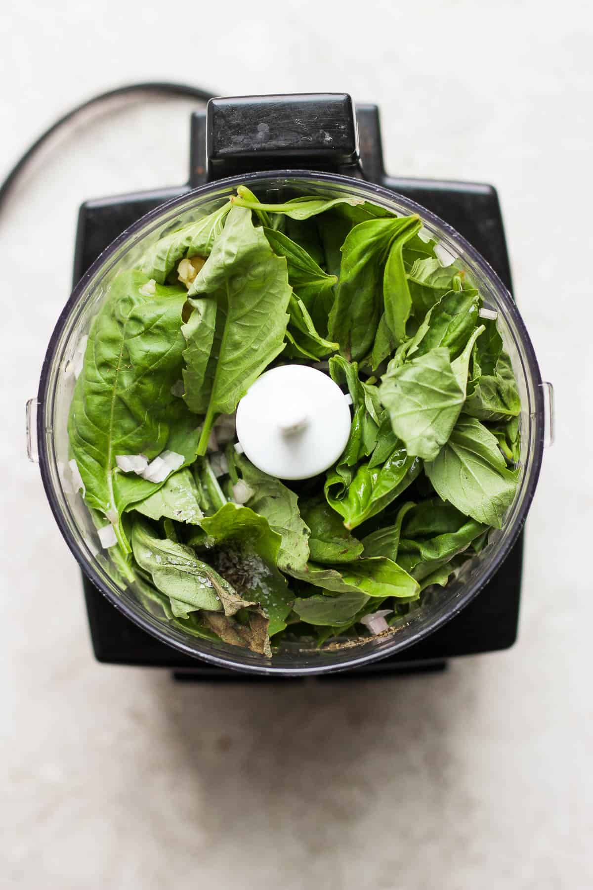 Basil vinaigrette ingredients in a food processor.