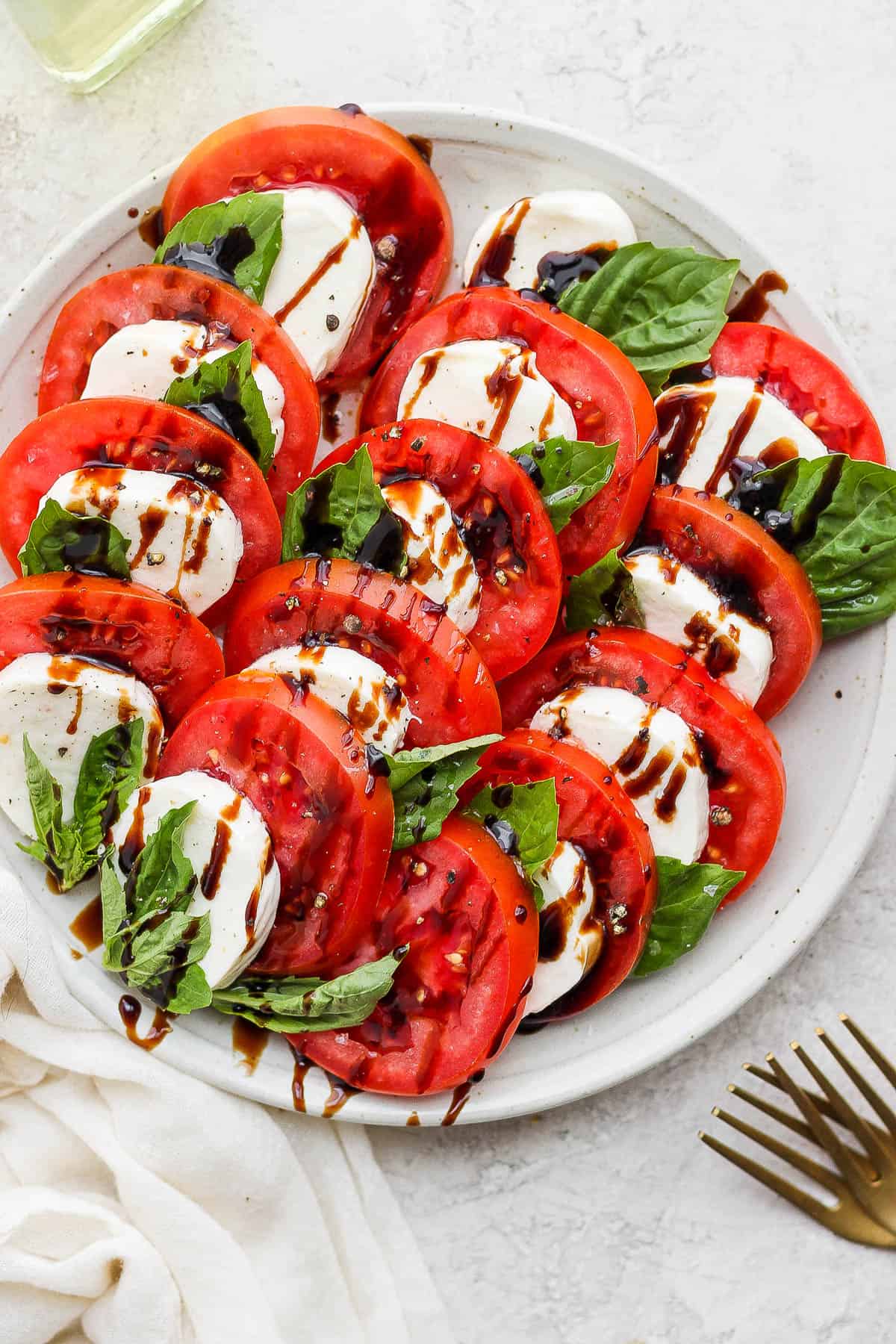 Olive oil and balsamic vinegar drizzled on top of the tomatoes, cheese, and basil.
