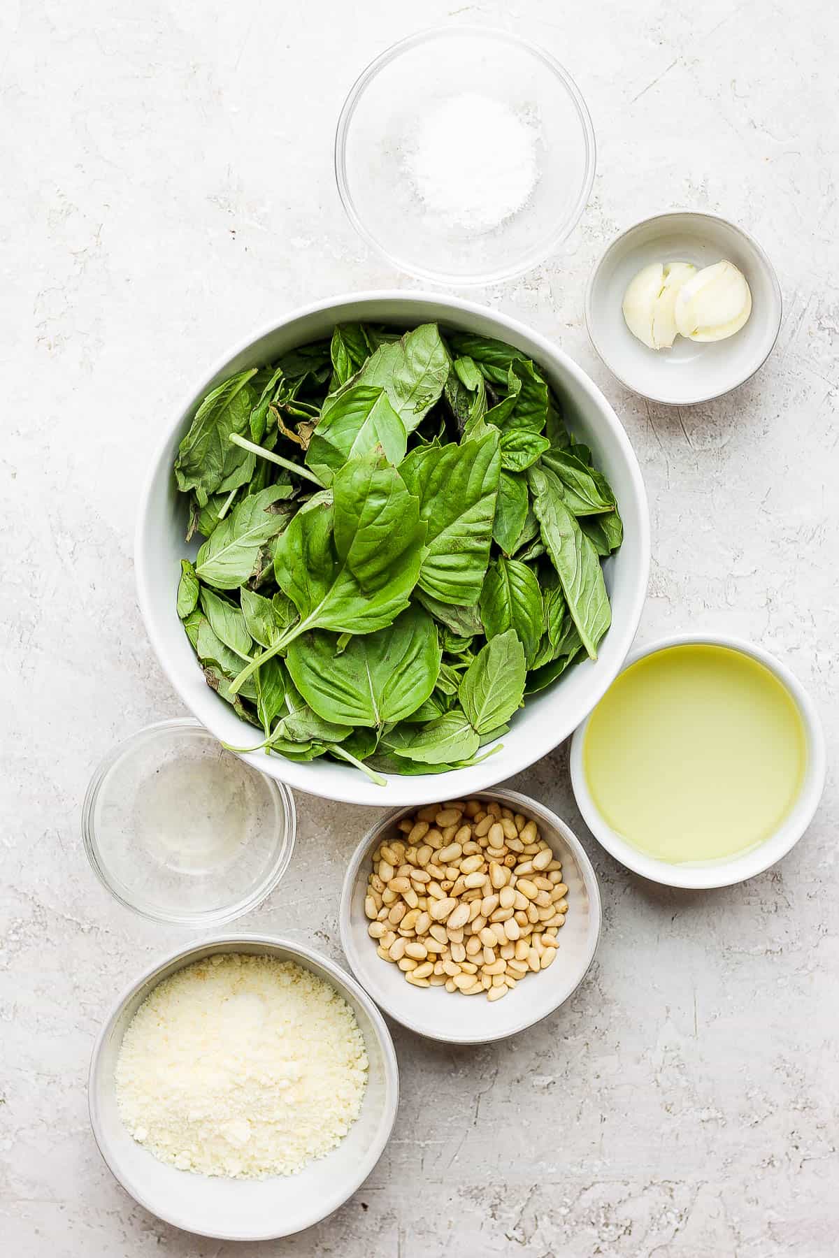 Ingredients for homemade pesto in separate bowls.