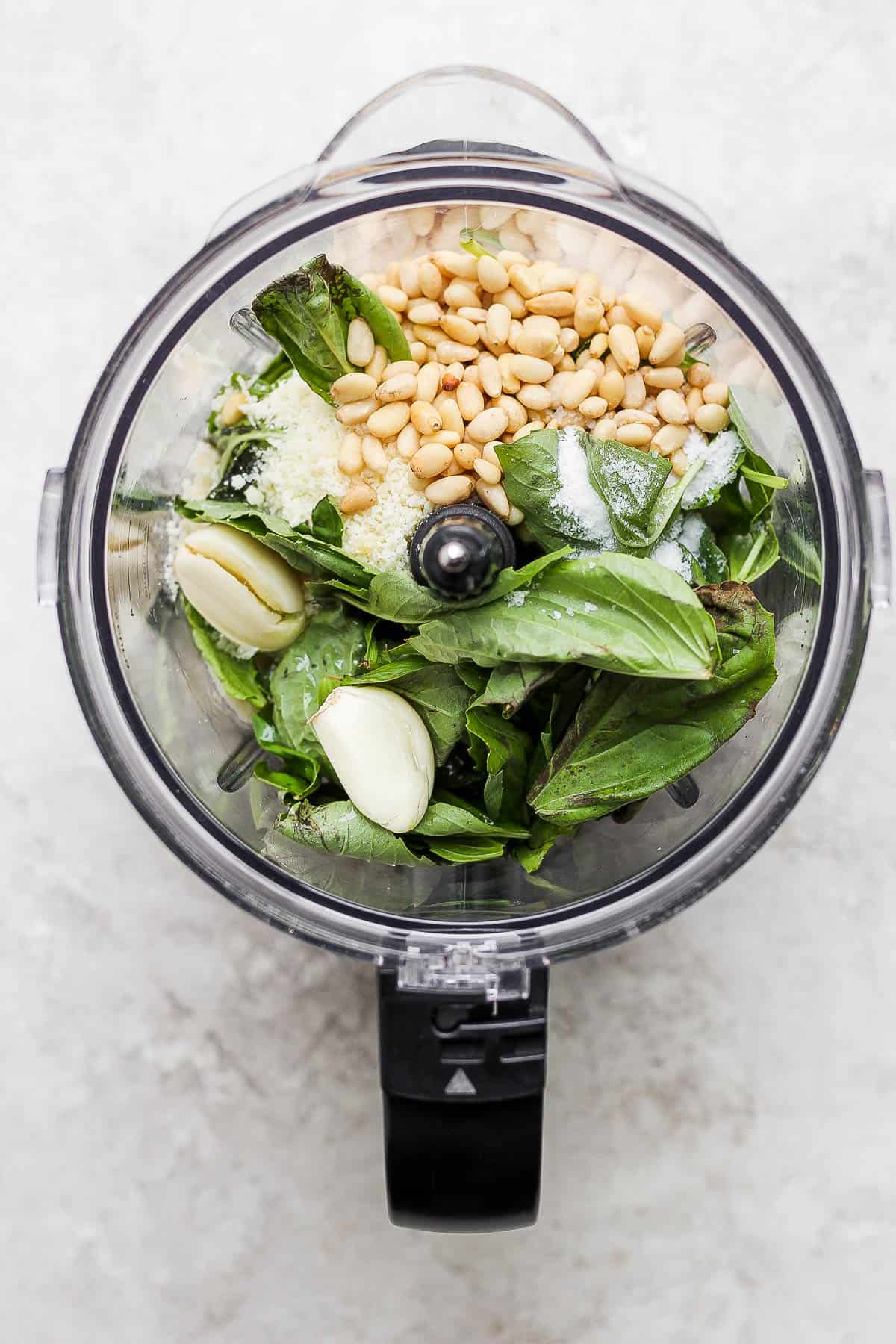 Pesto ingredients in a food processor.