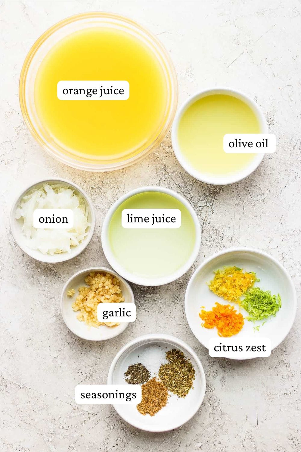 Mojo chicken marinade ingredients including orange juice, olive oil, onion, lime juice, garlic, citrus zest, and seasonings.