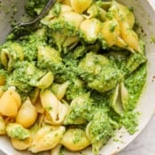 Pesto pasta in a bowl with cooked shell pasta covered in homemade pesto sauce.