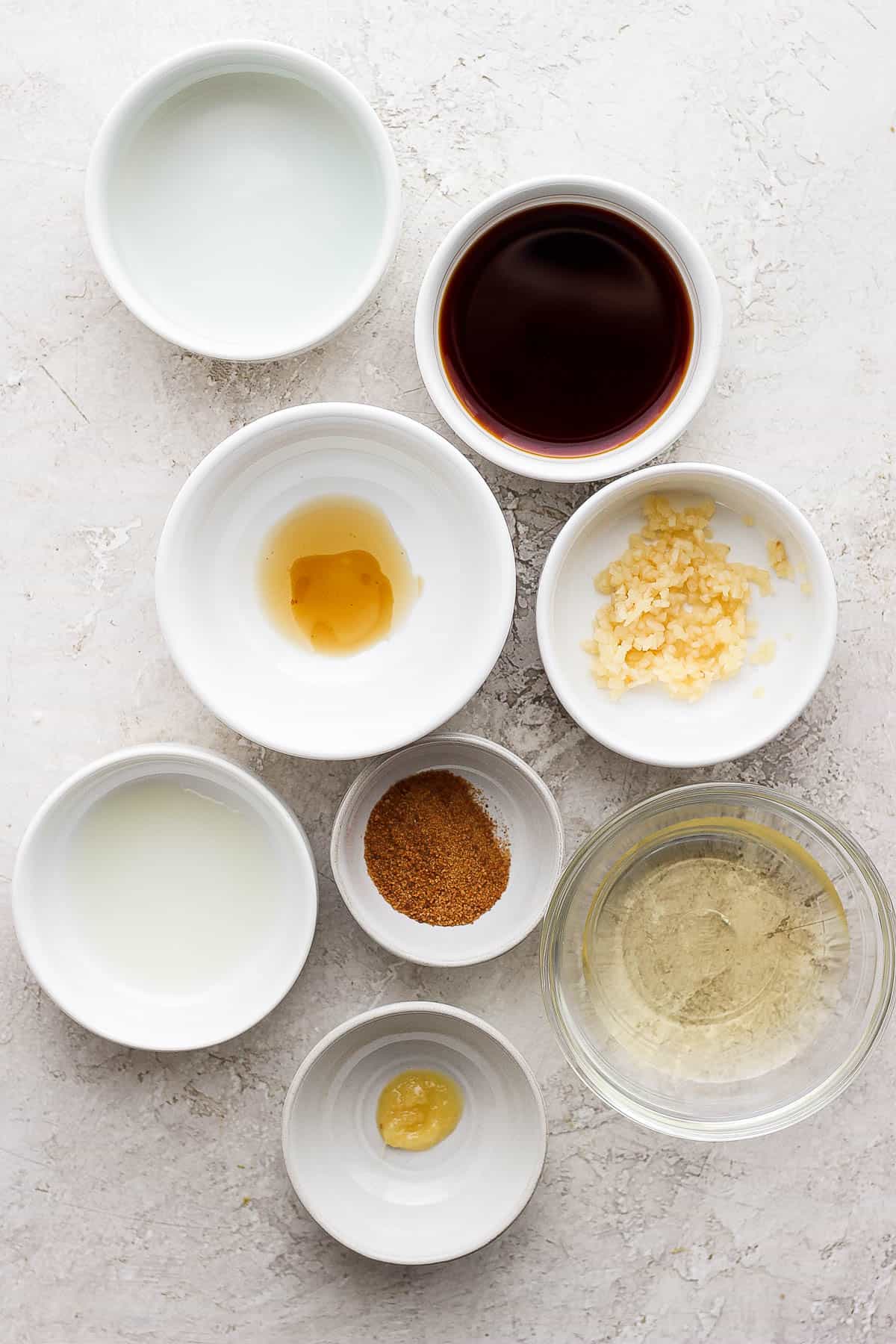 Ingredients for the sesame ginger dressing in separate bowls.