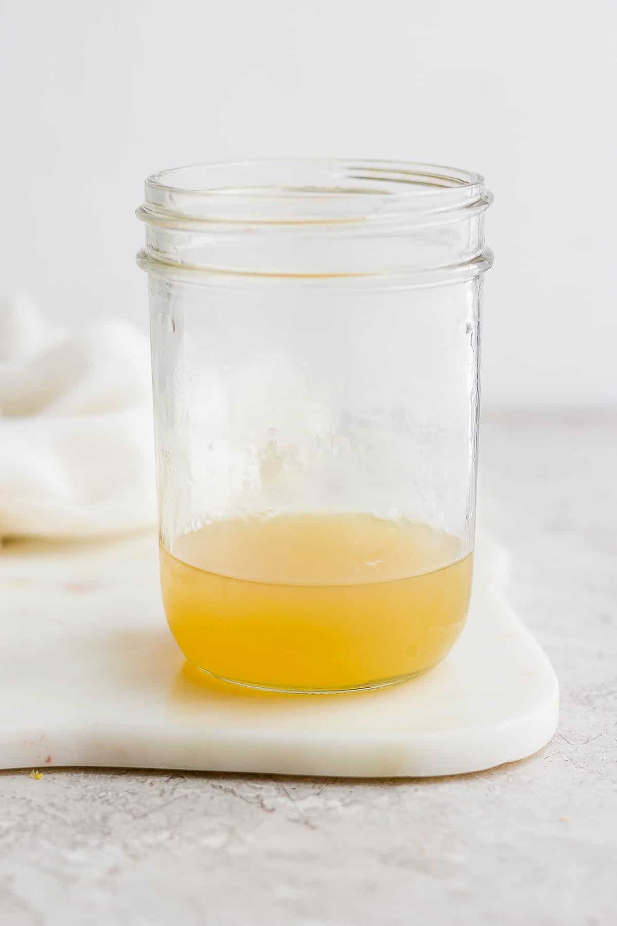 Ingredients for a whiskey sour in a glass mason jar.