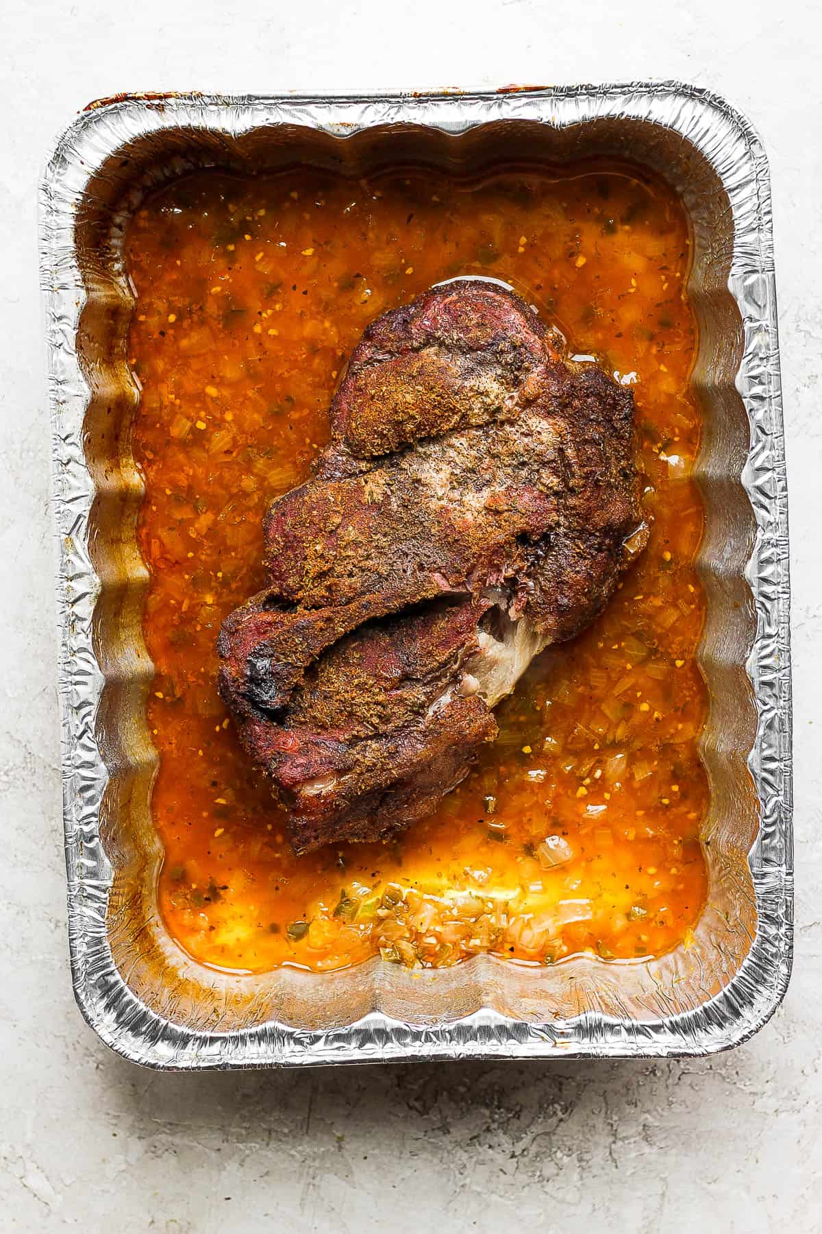 Pork shoulder in the braising liquid after it is fully cooked.