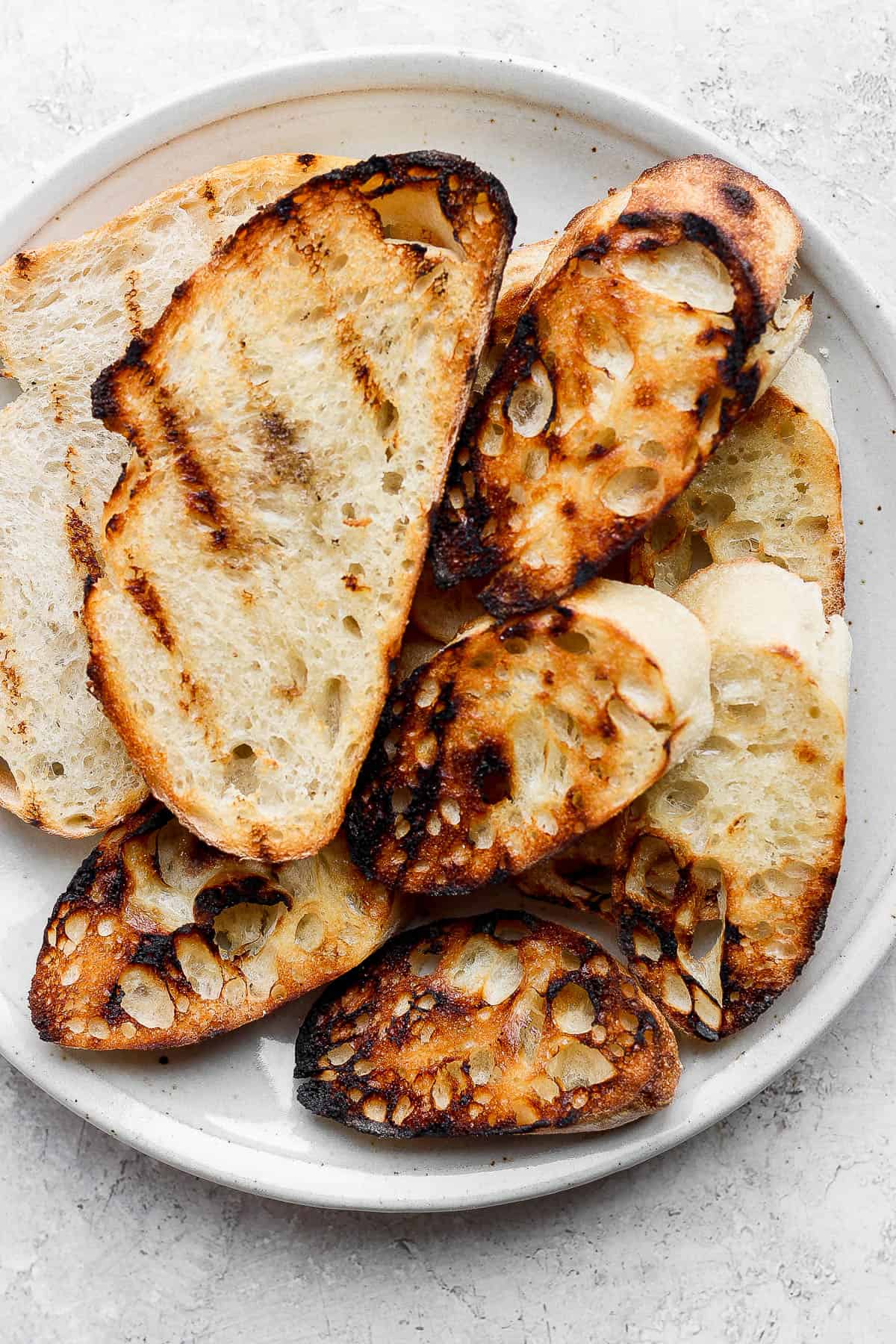 Slices of grilled bread and crostini on a plate.