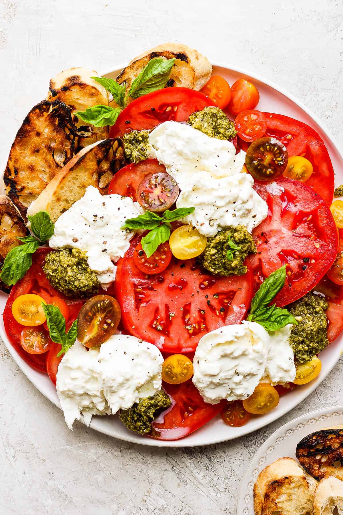 A large platter with the best tomato burrata salad.