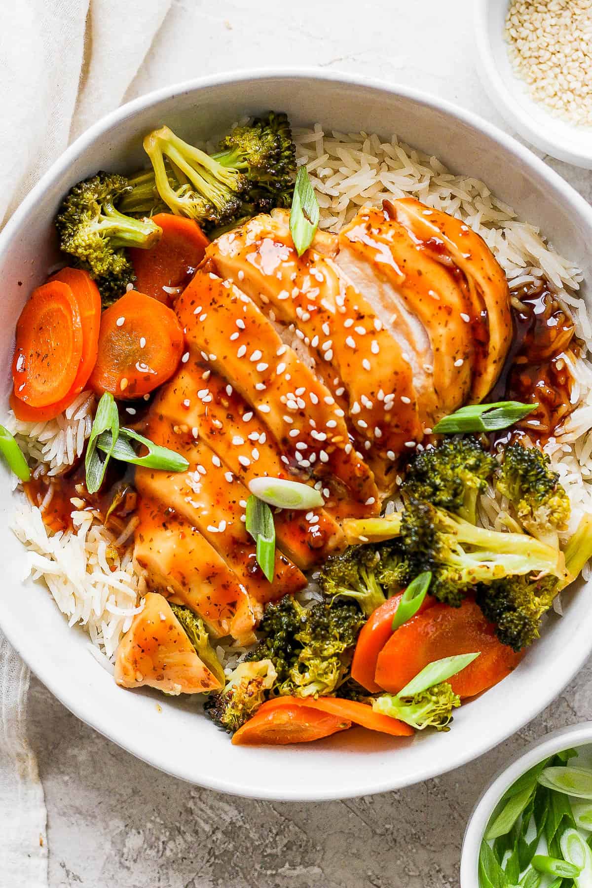 Baked teriyaki chicken over rice in a bowl.
