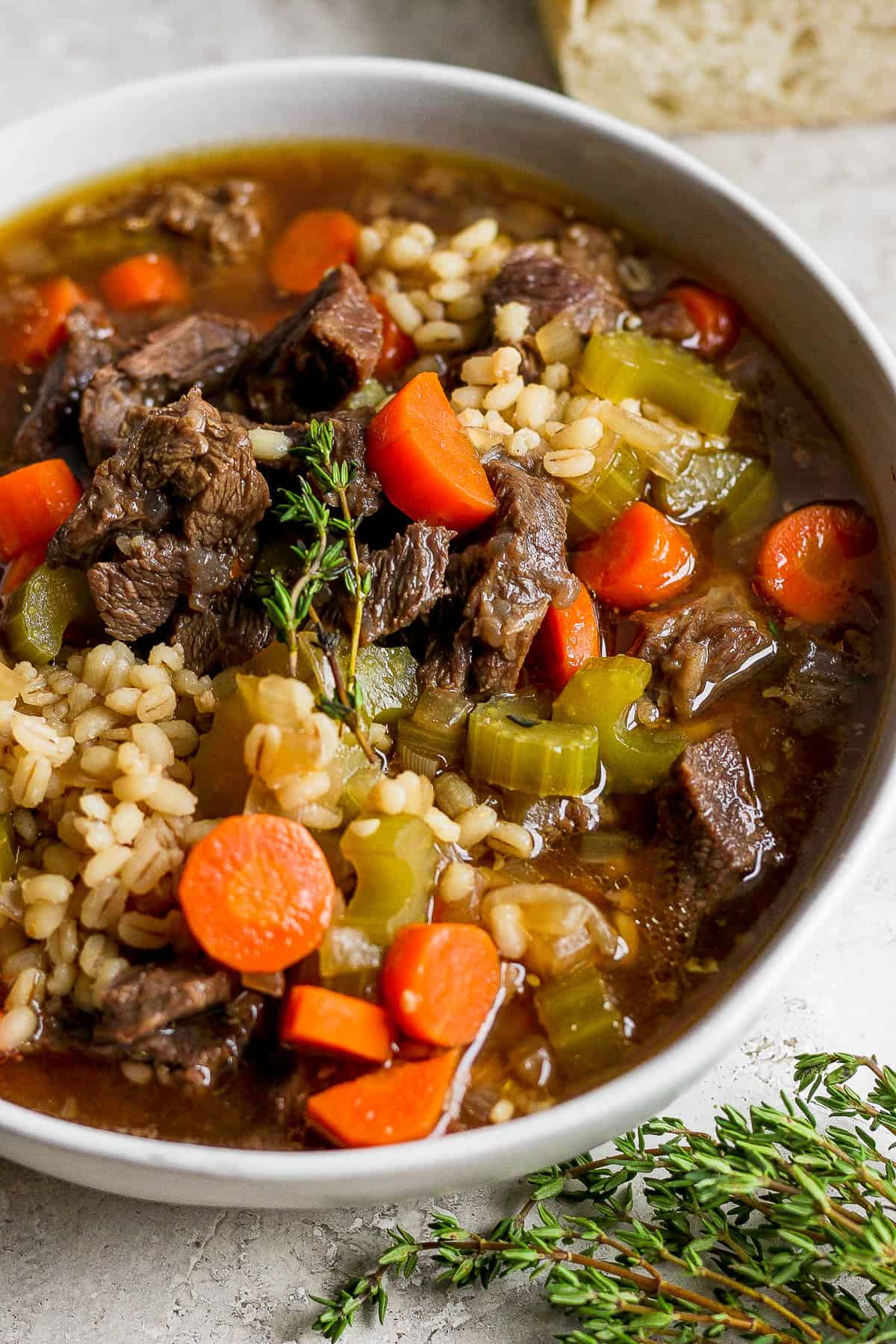 A close up of beef and barley soup in a bowl.