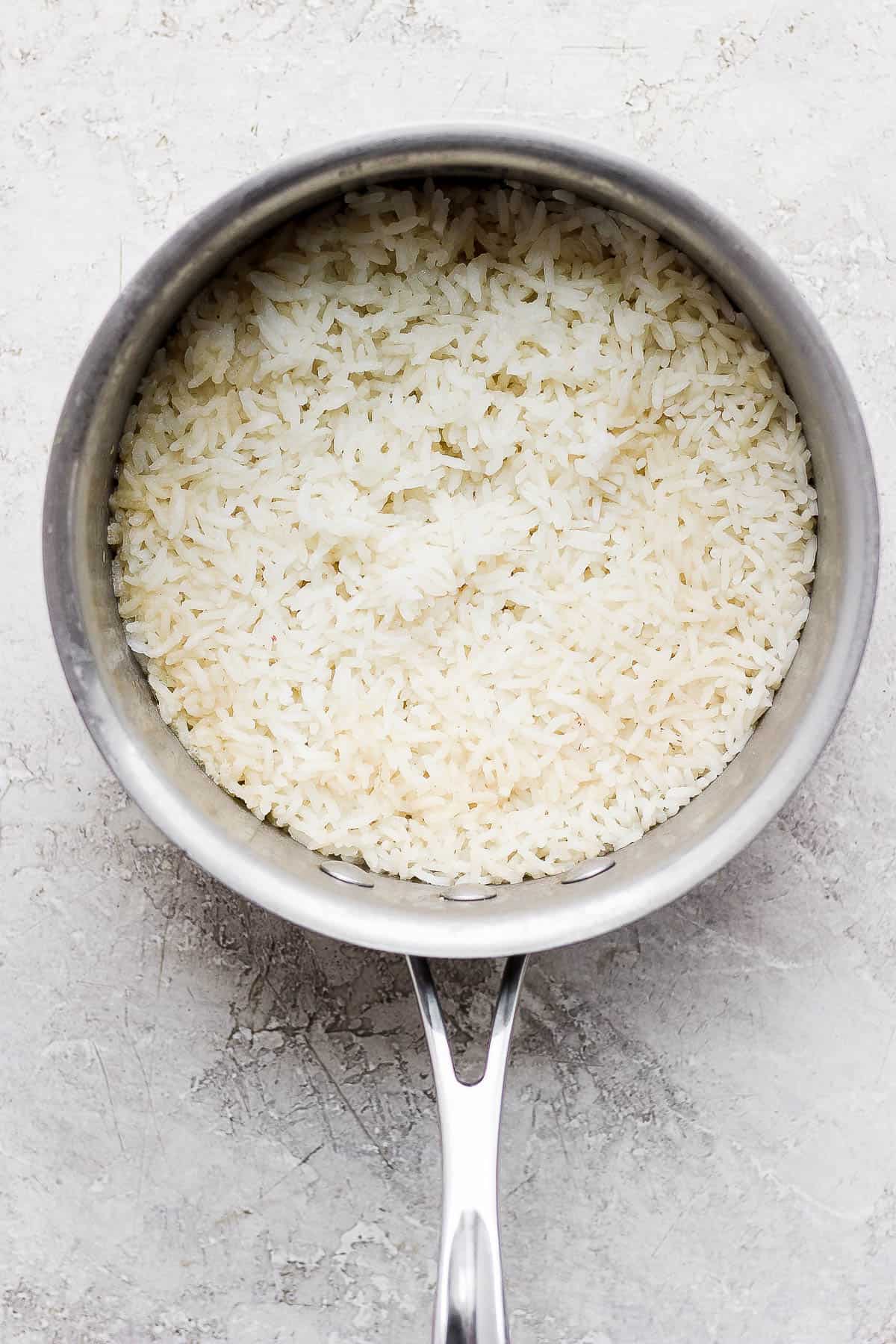 A pot of cooked long grain white rice.