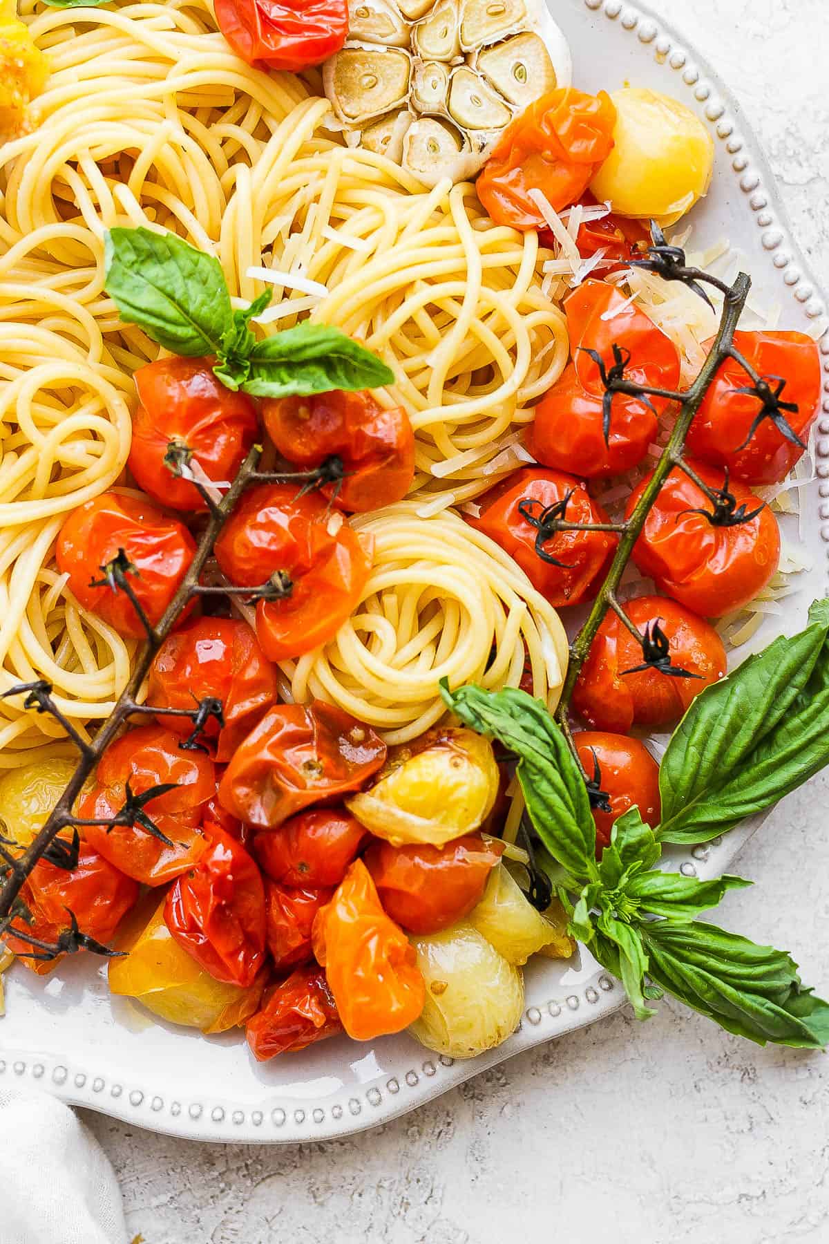 Cherry tomato pasta on a plate garnished with fresh basil leaves.