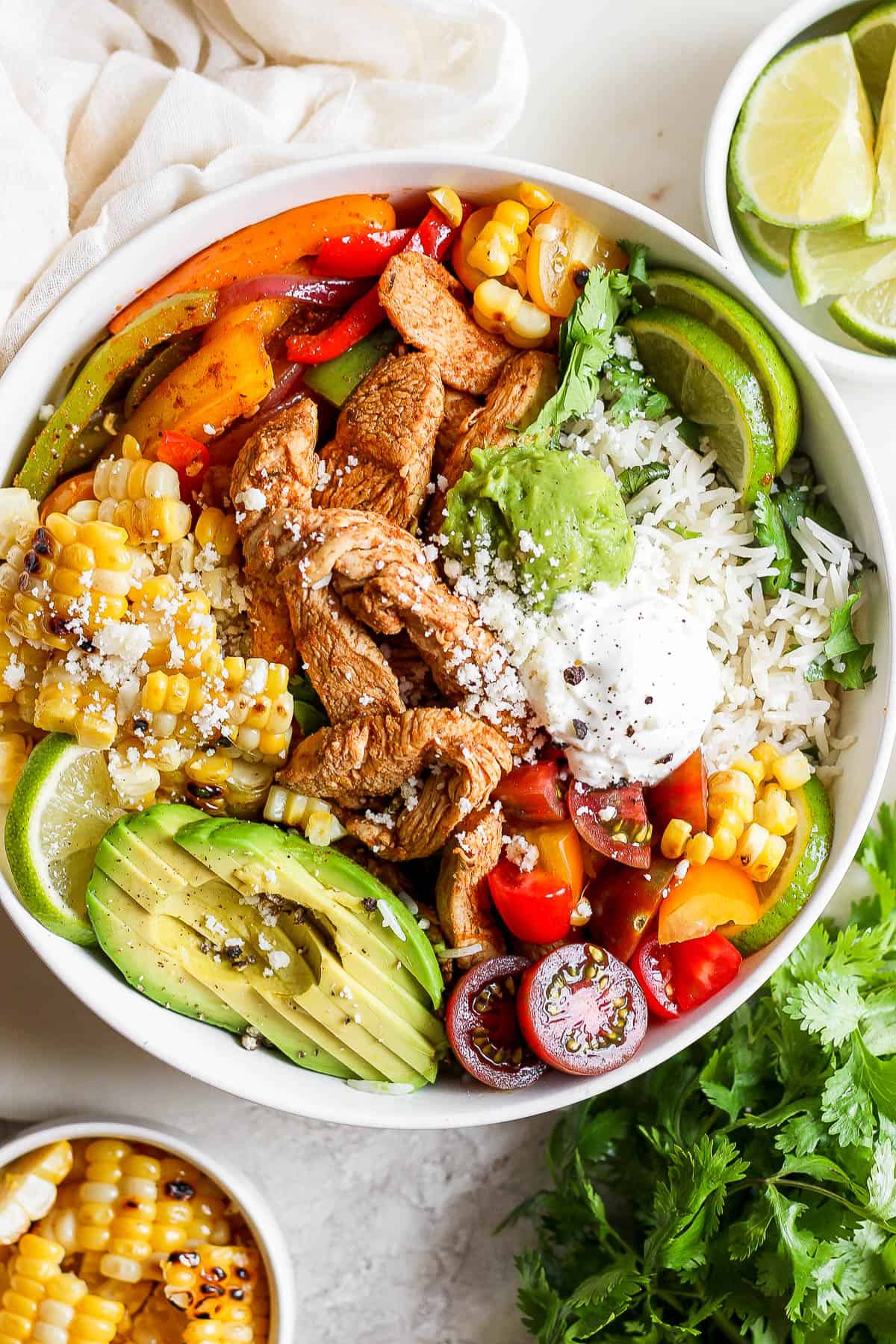 A fully topped chicken fajita bowl in a white bowl.