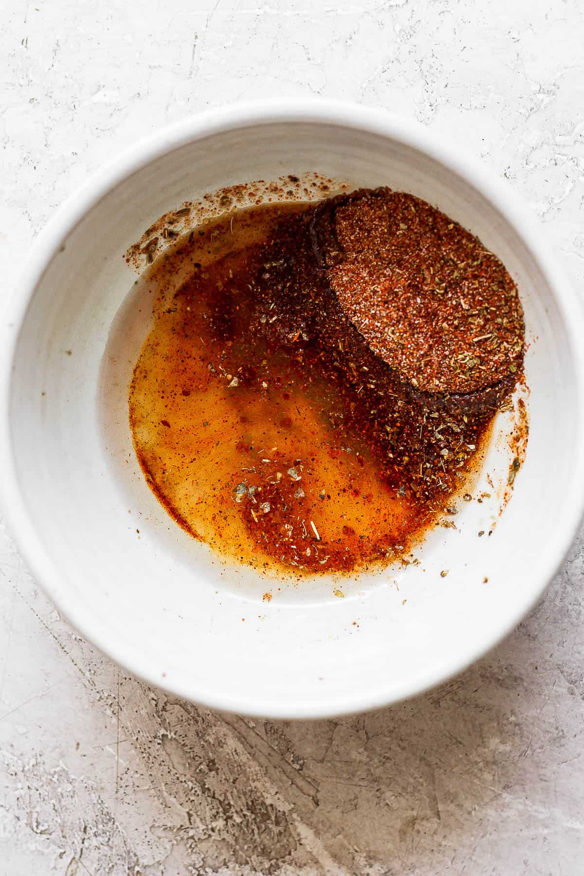 The marinade ingredients in a small, white bowl.