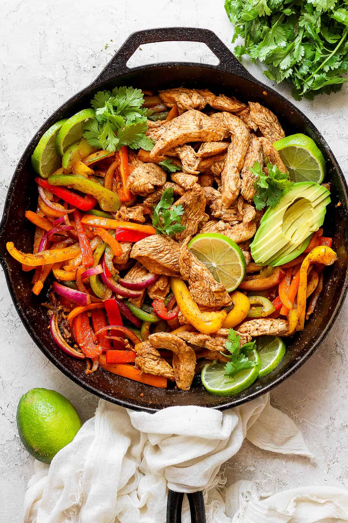 Cooked fajita chicken and veggies in a cast iron skillet.