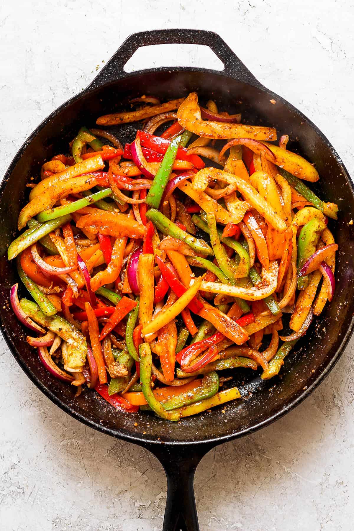 Cooked fajita veggies in a large skillet.