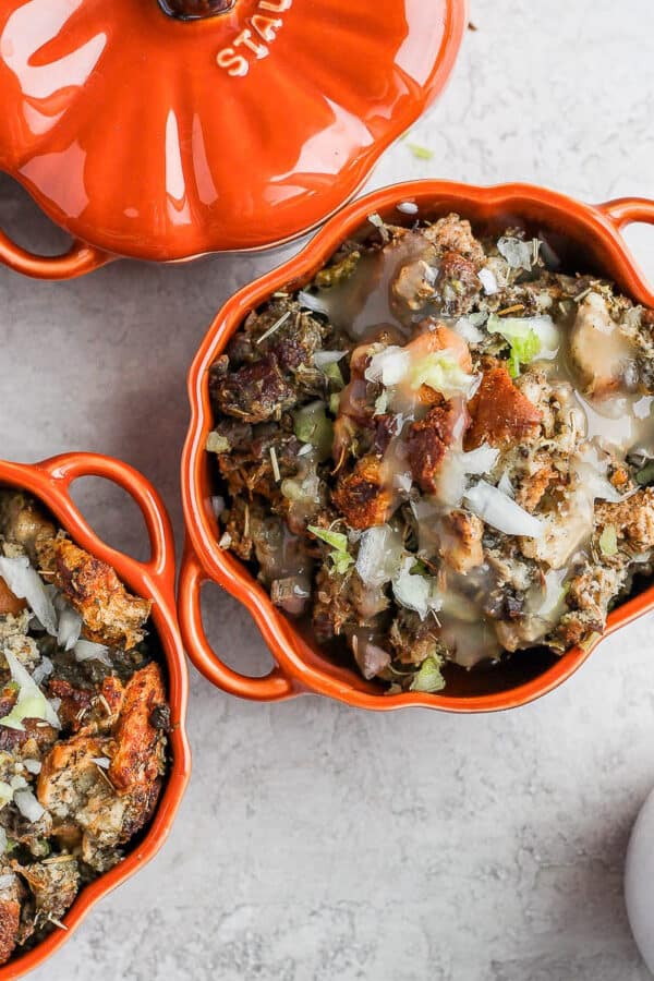 Four small ramekins filled with homemade giblet stuffing and a little gravy on top.