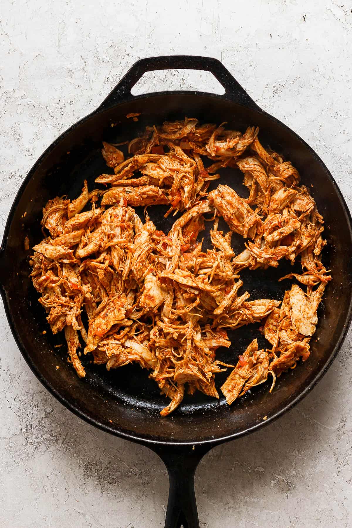 Shredded taco chicken in a large skillet.