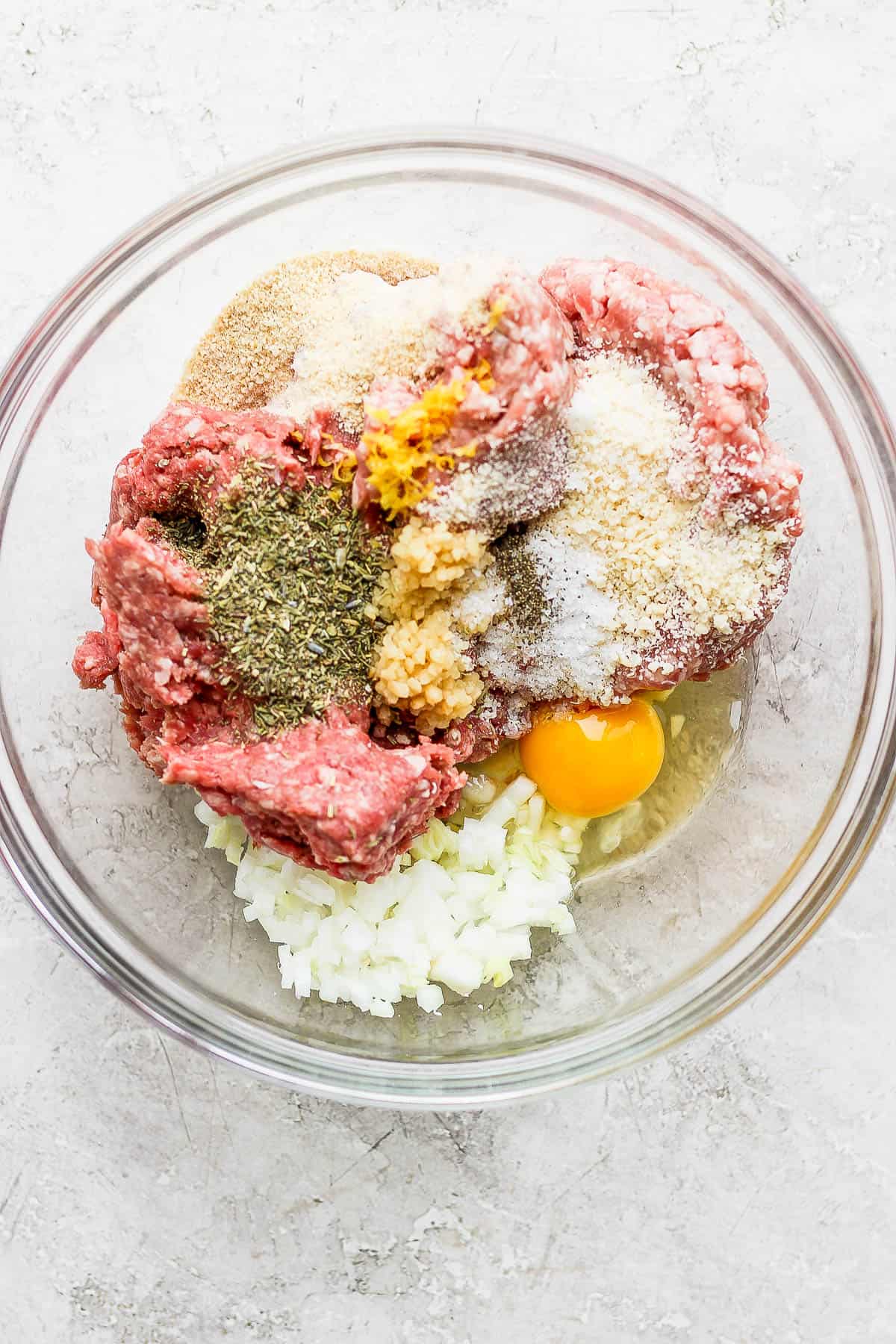 ground beef, ground pork, italian seasoning, lemon zest, grated onion, egg, breadcrumbs, salt and pepper in a mixing bowl.