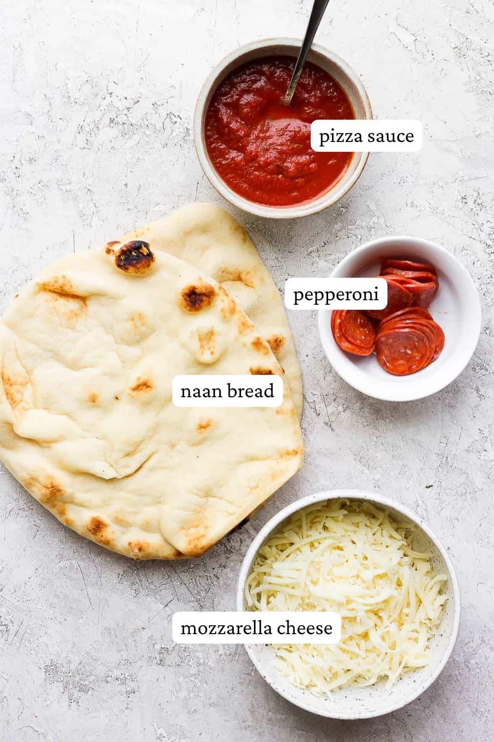 Flatbread Naan pizza ingredients including pizza sauce, naan flatbread, pepperoni, and mozzarella cheese.