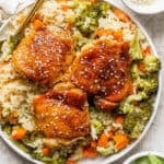 Top down shot of a plate of teriyaki chicken and rice with sesame seed garnish and a fork on the side.