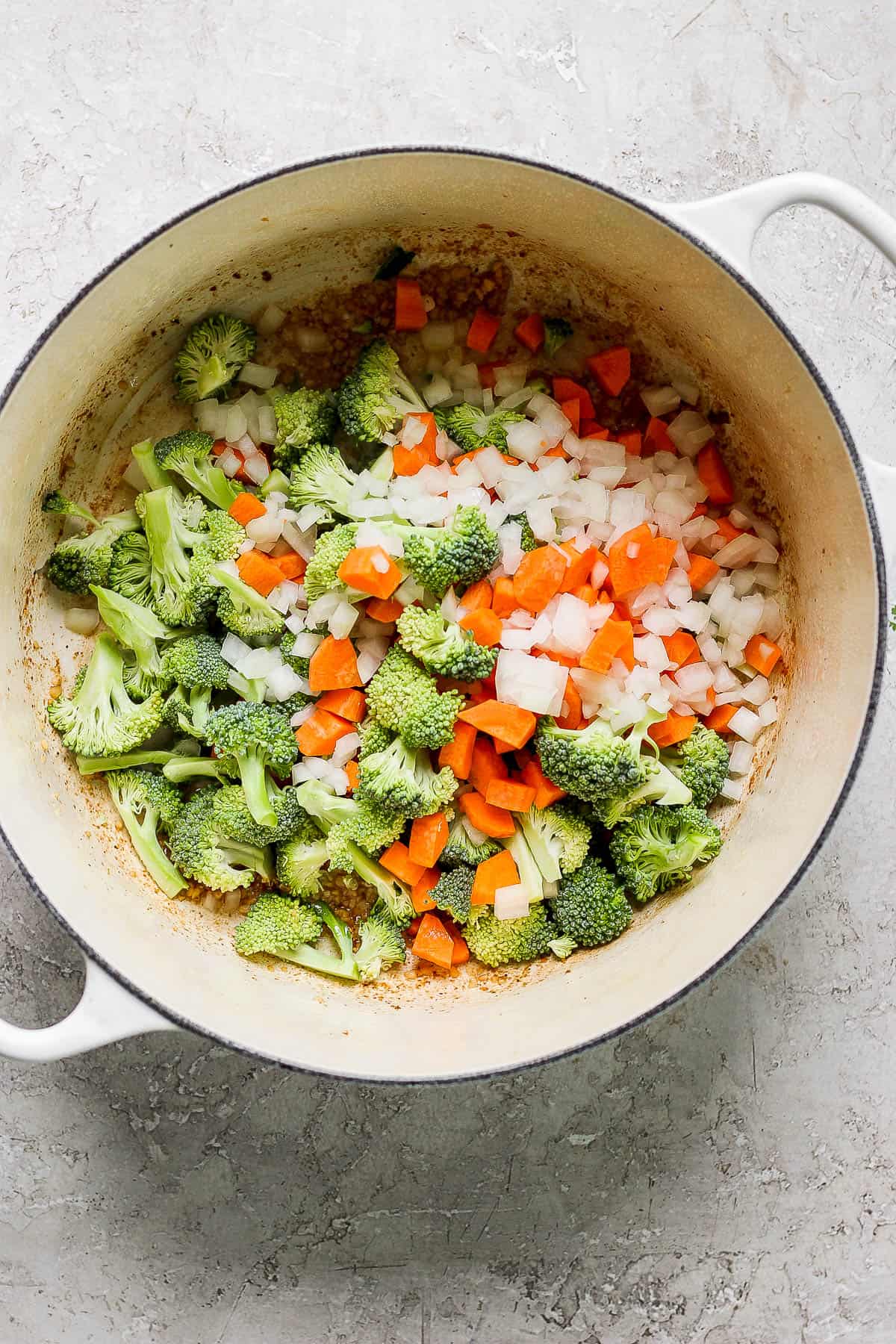 Chicken removed from the pot and garlic, onion, carrots, and broccoli added in.