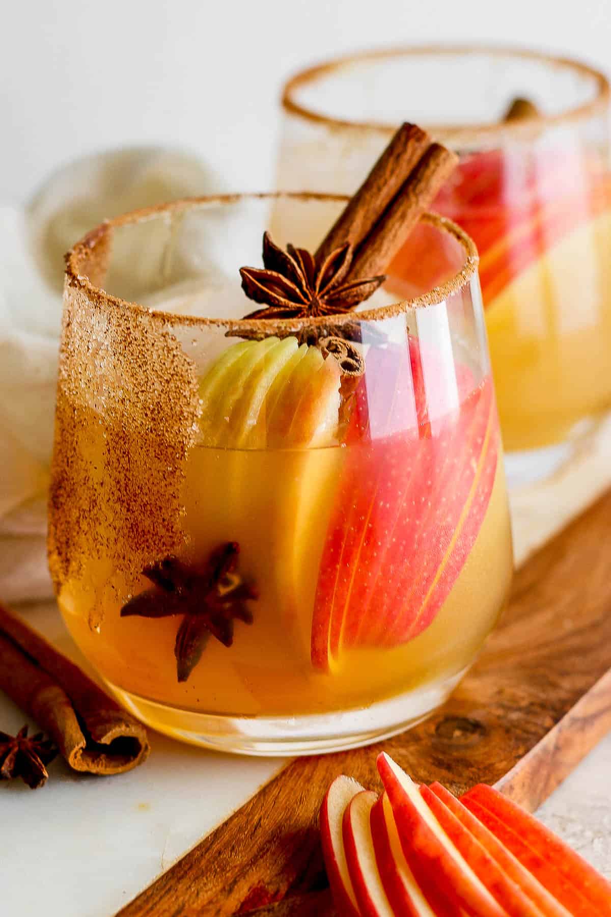 Apple cider margarita garnished with apple slices, star anise, and a cinnamon stick.