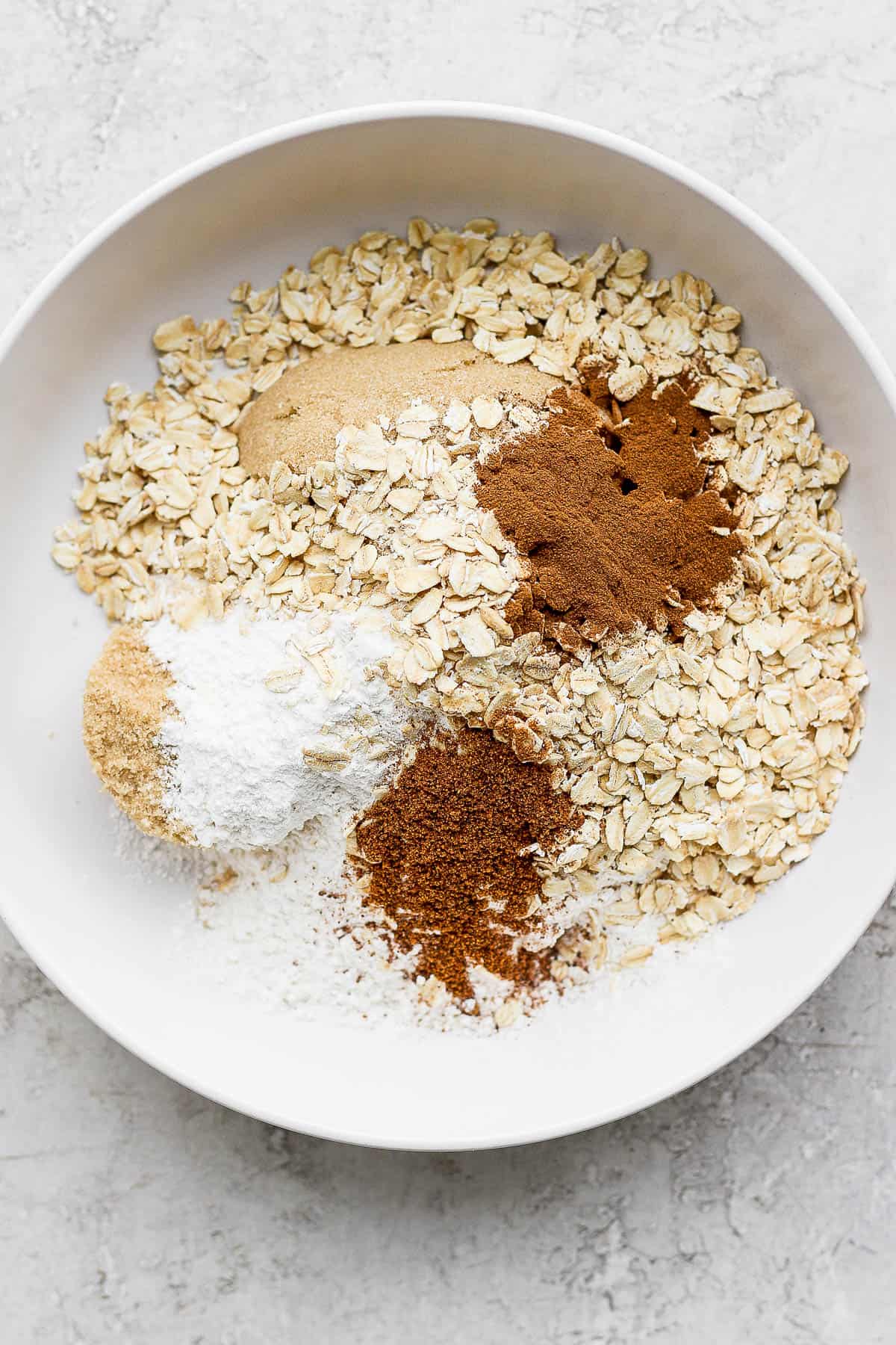 Dry ingredients for the apple filling in a white bowl.