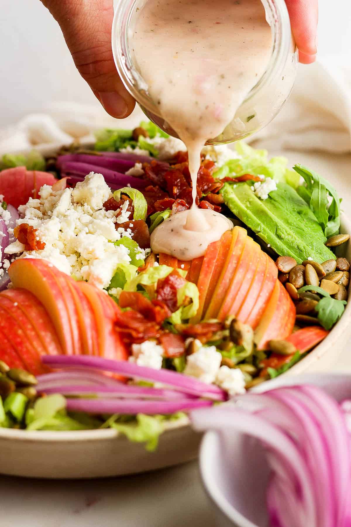 Champagne Vinaigrette being poured on a thanksgiving salad.