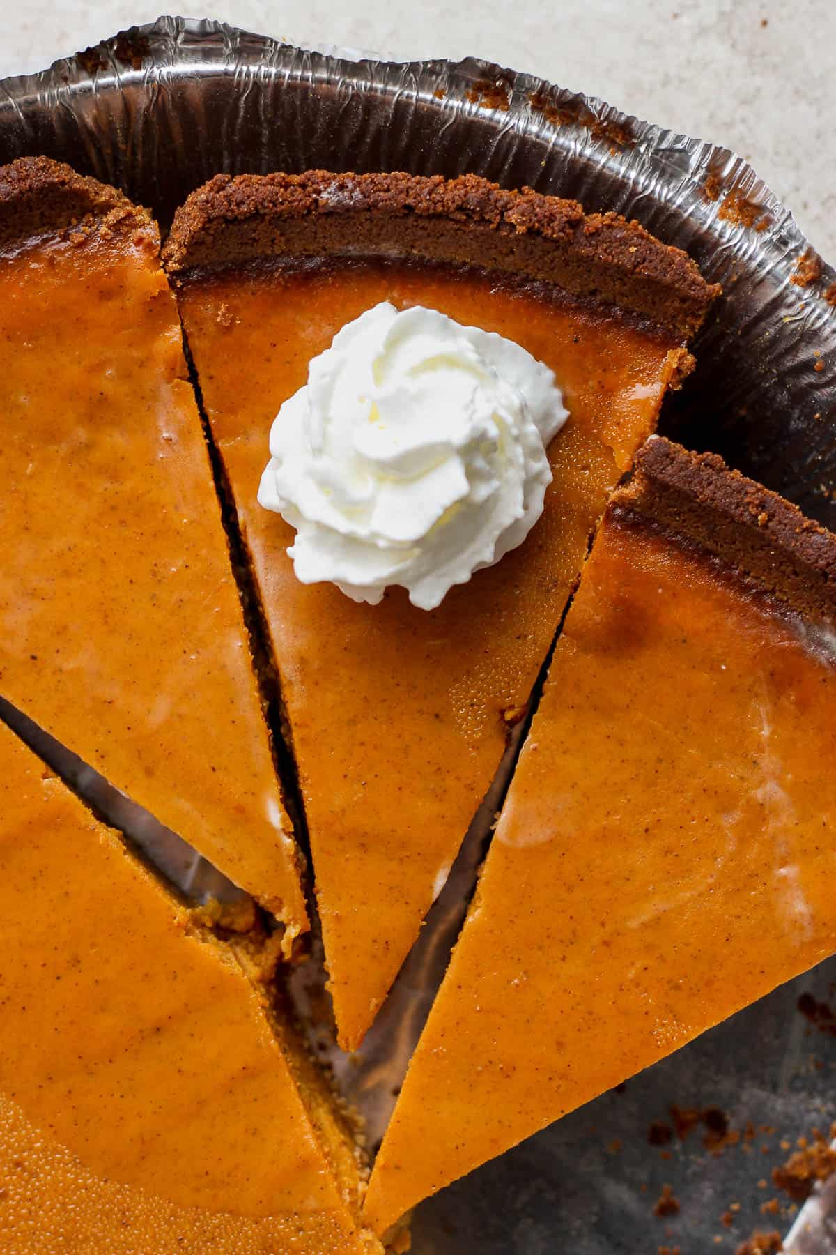 Pumpkin pie slices in an aluminum pie tin.