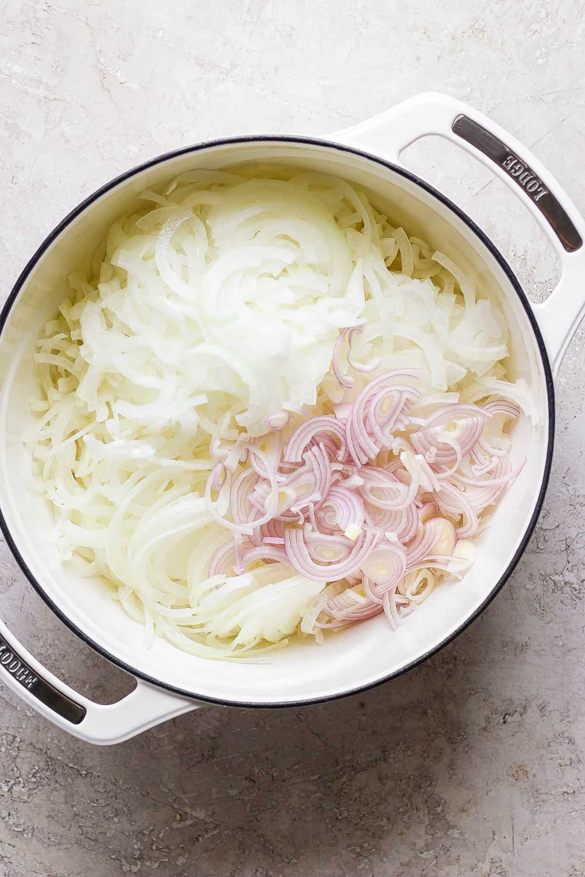 Sliced onions and shallots added to the dutch oven.