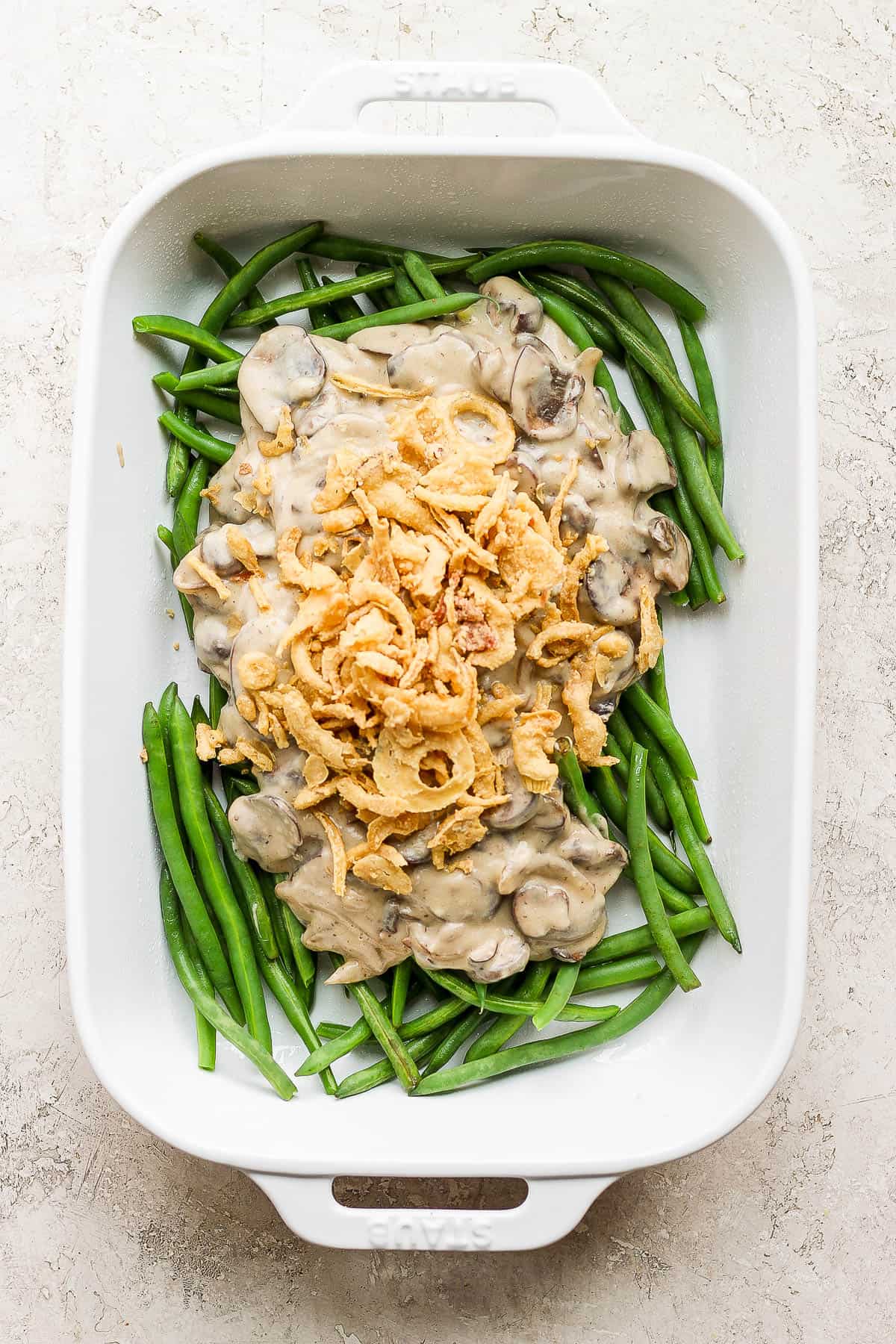 The mushroom sauce added to the baking dish with the green beans and 3/4 cup of the french onions also added.